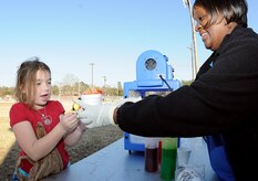 Nine-year old Jazmine Fraize spends her hard earned play money on a Sno Cone, one of the many items participants could purchase with their cash at the Learn and Earn Carnival at Menriv Soccer Field at Joint Base Charleston-Weapons Station, Feb. 23. The carnival was held in conjunction with Military Saves Week and is designed to teach children money management and savings through fun interactive games. (U.S. Navy photo/Mass Communication Specialist 1st Class Jennifer Hudson