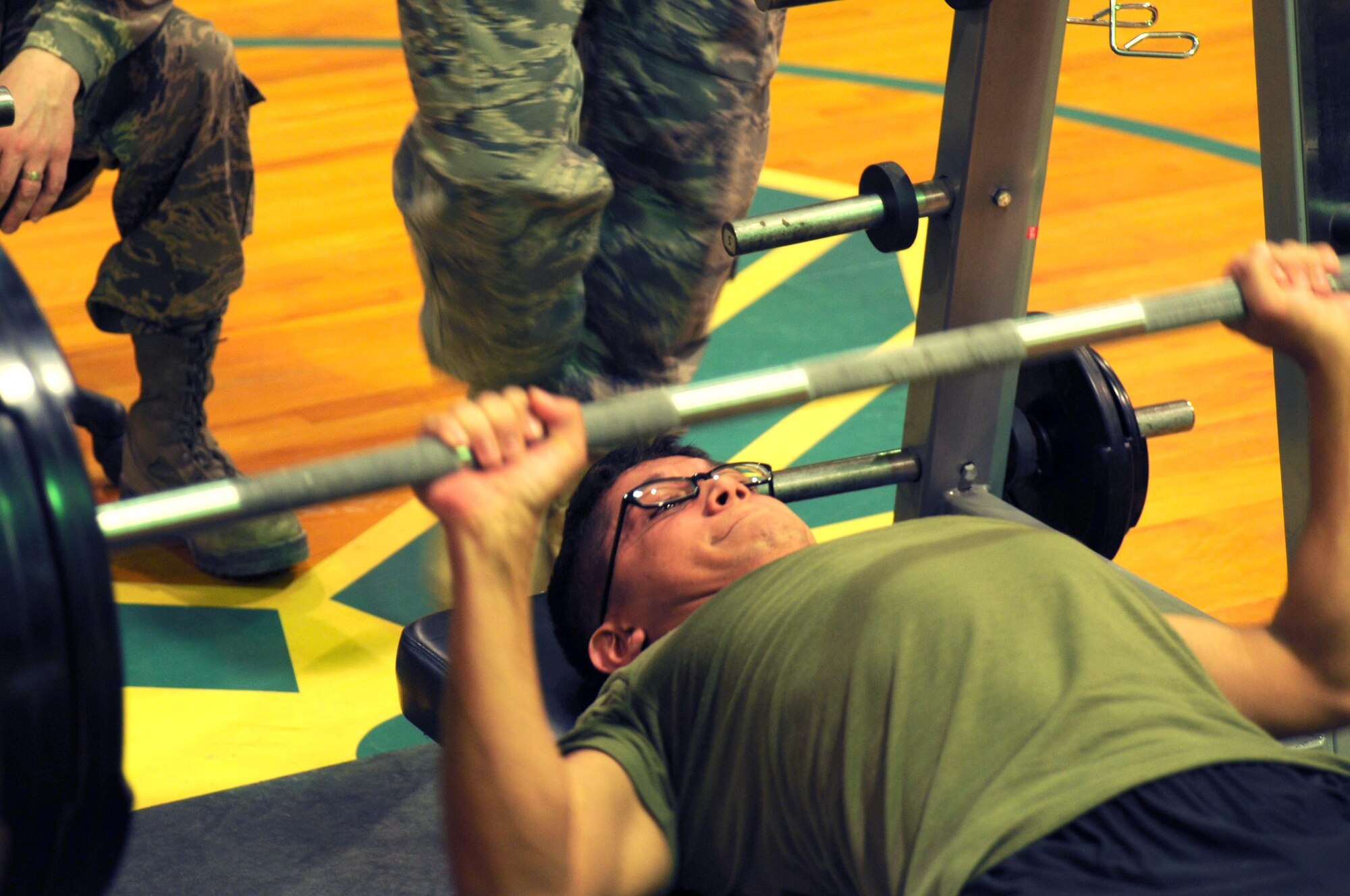 Lance Cpl. Lorenzo Villarreal attempts his first press during The Rock Bench Press Competition, Feb. 12. Participants were broken down into age categories and were allowed to press three attempts of their chosen weight. (U.S. Air Force photo by Staff Sgt. Patrice Clarke)