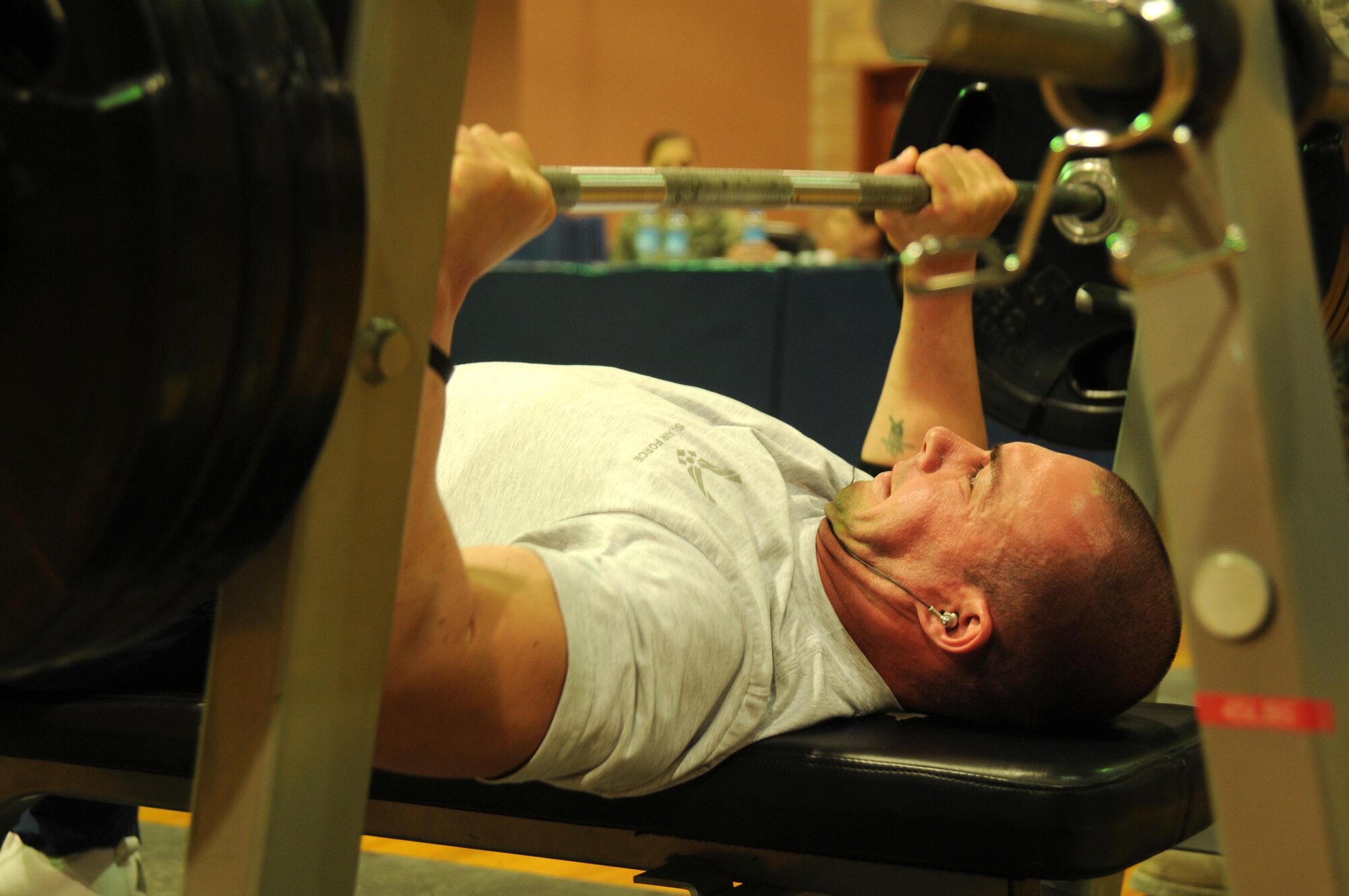 Staff Sgt. Jeremy Dawley, 386th Expeditionary Security Forces Squadron, focuses on pushing up his second attempt Feb. 12, during the Rock Bench Press Competition. Base members were given three attempts to successfully press their desired weight. (U.S. Air Force Photo by Staff Sgt. Patrice Clarke)