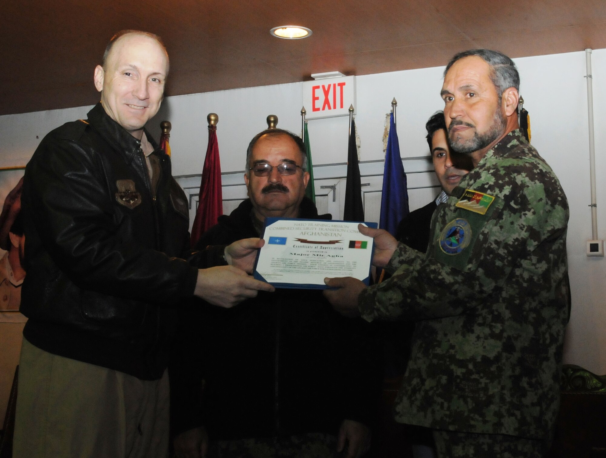 Afghan Air Force Maj. Mer Agha, the AAF’s aviation life Support equipment shop chief, receives a certificate in recognition of his halting a false promotion during a ceremony at the Afghan Air Force Base in Kabul Feb. 22. (U.S. Navy photo by Mass Communications Specialist 3rd Class Jared Walker)