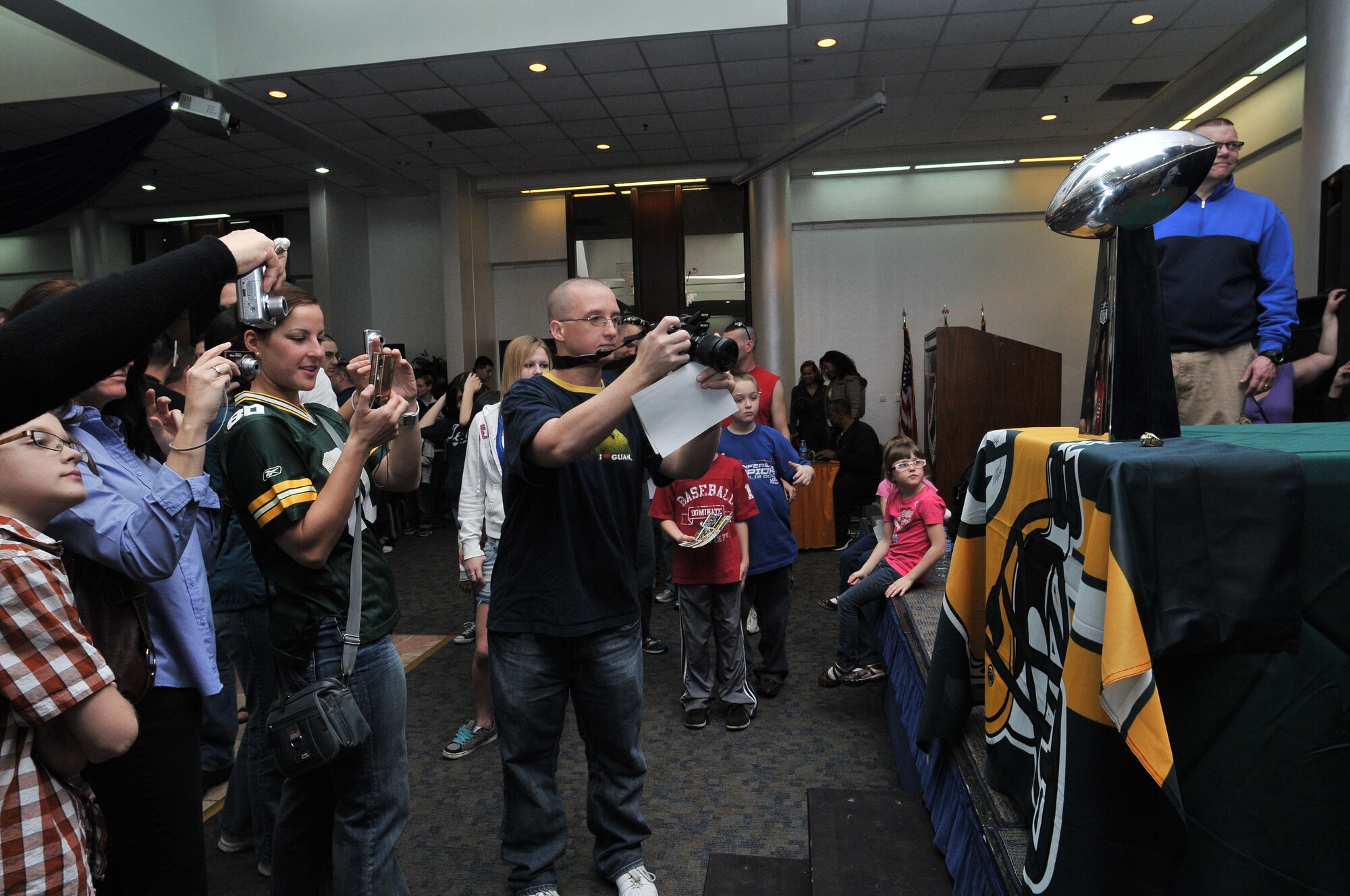Incirlik Airmen and families take photos of and with a replica of the National Football League Vince Lombardi Trophy and Super Bowl XLV championship rings during a visit from the Green Bay Packers to Incirlik Air Base, Turkey, Feb. 12, 2011. The trip was organized by Navy Entertainment and the 39th Force Support Squadron as part of the NFL team’s “Tundra Tour.” Super Bowl XLV champions Jarrett Bush, Derrick Martin, William Henderson, Frank Zombo, Nick McDonald, and Daryn Colledge, as well as Pepper Burruss, the head athletic trainer for the Packers, conducted a behind-the-scenes presentation and an autograph session during their visit to the base. (U.S. Air Force photo by Staff Sgt. Alex Montes)