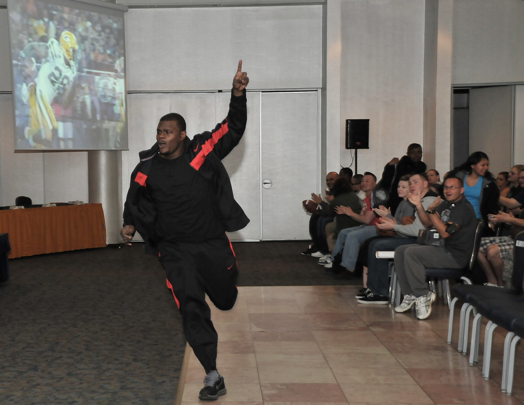 Derrick Martin, a safety from the National Football League team the Green Bay Packers, makes an entrance during a visit to Incirlik Air Base, Turkey, Feb. 12, 2011. The trip was organized by Navy Entertainment and the 39th Force Support Squadron as part of the team’s “Tundra Tour.” Super Bowl XLV champions Jarrett Bush, Derrick Martin, William Henderson, Frank Zombo, Nick McDonald, and Daryn Colledge, as well as Pepper Burruss, the head athletic trainer, conducted a behind-the-scenes presentation and an autograph session during their visit to the base.   (U.S. Air Force photo by Staff Sgt. Alex Montes)