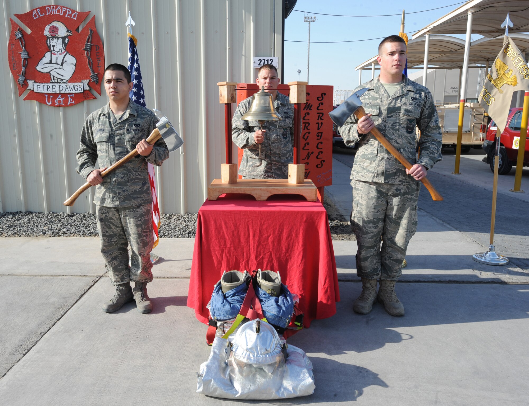Senior Airman Robert McCallon, 380th Expeditionary Civil Engineer Squadron Fire Department, rings the bell during a "Last Alarm" Memorial Ceremony for Airman 1st Class Derek V. Kozorosky, 18th Civil Engineer Squadron Fire Department, on Feb. 16, 2011, in Southwest Asia. (left to right) Airmen 1st Class Parker Bass and Daniel Garcia, both with the 380th ECES fire department, flank the bell ringer holding axes. Airman Kozorosky passed away while actively engaged in fire protection duties the week prior to the ceremony. (U.S. Air Force photo by Airman 1st Class Maynelinne De La Cruz)