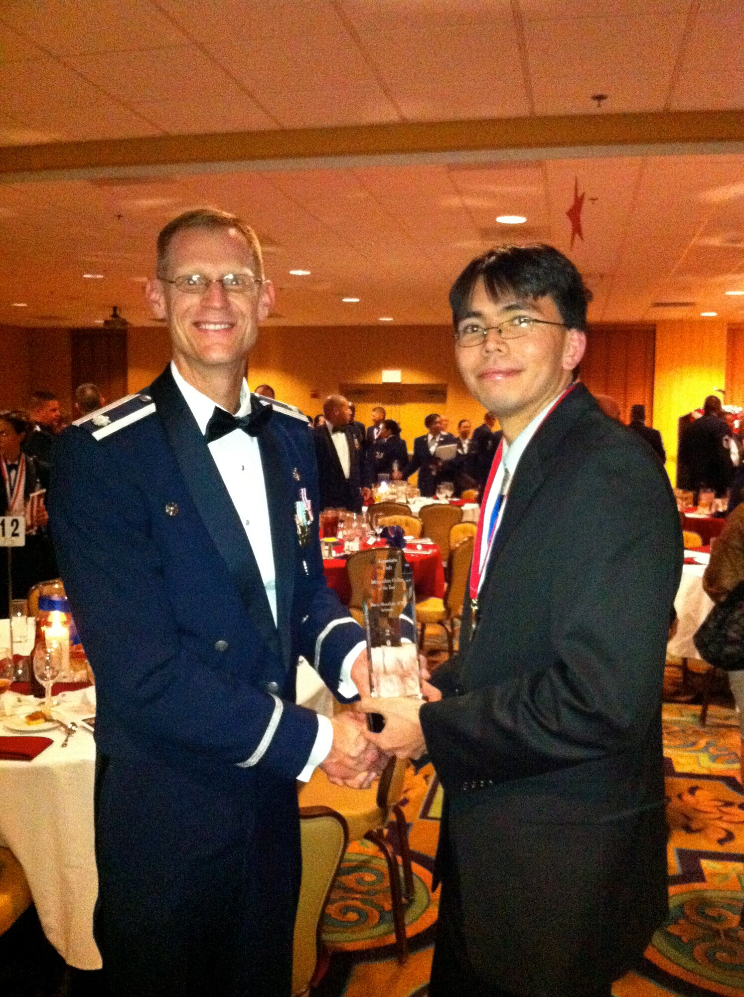 DAVIS-MONTHAN AIR FORCE BASE, Ariz. -- Lt. Col. Lee Byerle, 25th Operational Weather Squadron commander, congratulates Stephen Bieda on winning the Associated Unit Intermediate Civilian of the Year award at the Desert Lightning Team annual awards ceremony Feb. 5 held at the Mirage Club here.

