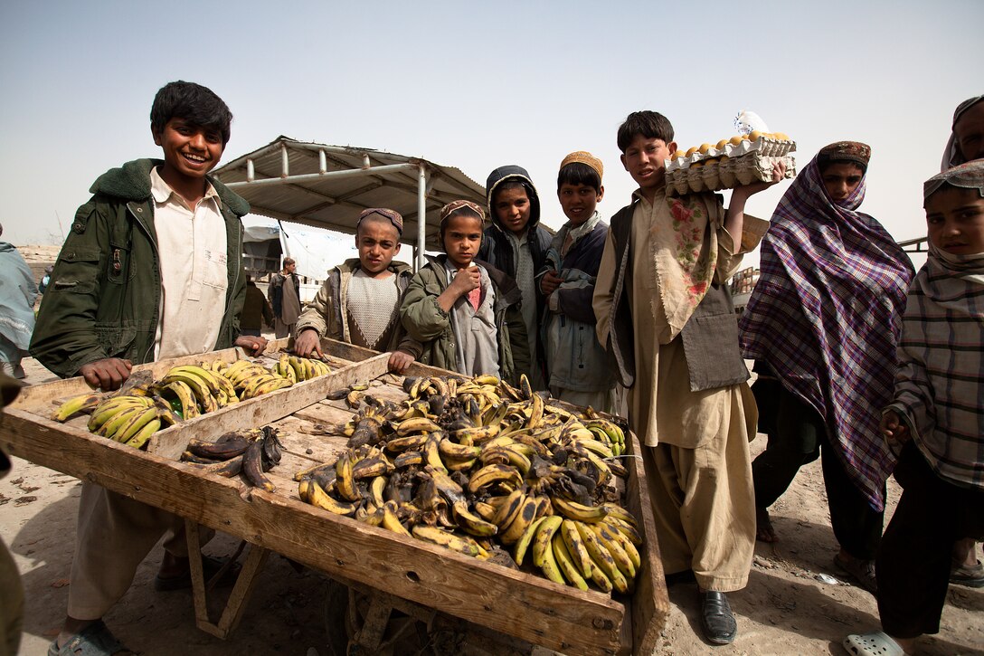 Local merchants sell produce at Khalaj Bazaar, Garmsir District, Helmand province, Afghanistan, on "Bazaar Friday," Feb. 25. On Fridays, Khalaj Bazaar draws an average of about 3,000 villagers who gather to buy and sell livestock, meat, poultry, textiles, and various wares. The bazaar draws traders from as far as Herat province, in Western Afghanistan.