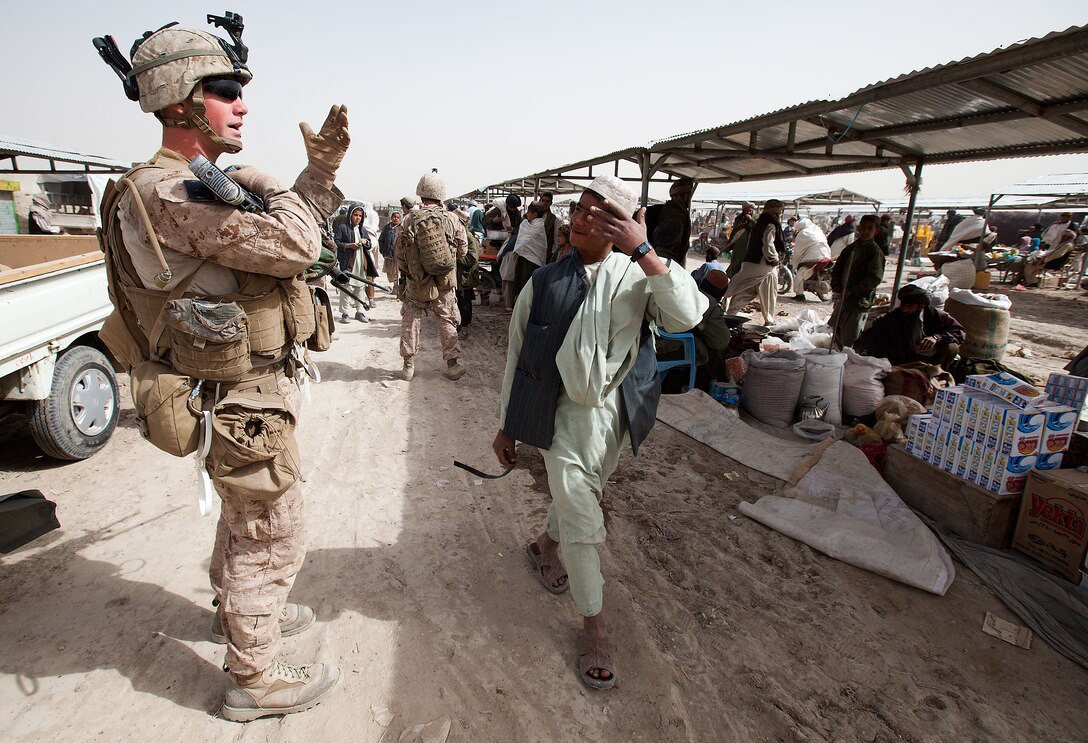 Lance Cpl. Christopher Willis, a Squad Automatic Weapon Gunner with Golf Company, 2nd Battalion, 3rd Marine Regiment, exchanges banter with locals of Khalaj Bazaar, Garmsir District, Helmand province, Afghanistan, on “Bazaar Friday,” Feb. 25. On Fridays, Khalaj Bazaar draws an average of about 3,000 villagers who gather to buy and sell livestock, meat, poultry, textiles, and various wares. The bazaar draws traders from as far as Herat province, in Western Afghanistan.