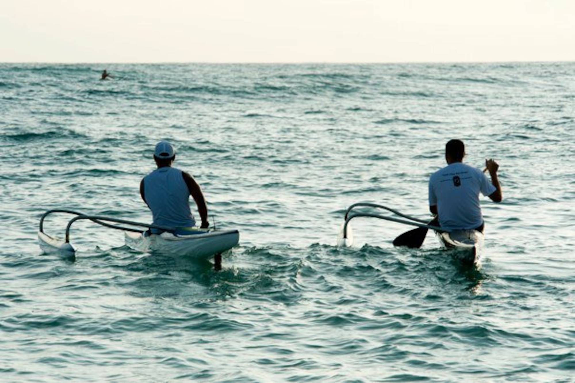 Master Sgt. Jeff Allen (left), a strategic plans technician with the Pacific  Air Forces public affairs office at Joint Base Pearl Harbor Hickam, and Tim Awaya, a graphic artist at JBPHH,  paddle their canoes throught the water off  Hickam Beach Feb. 17. "Paddling" is a popular local pastime in which paddlers brave the Pacific Ocean in outrigger canoes ranging in size from one to six passengers. (U.S. Air Force photo by Staff Sgt. Nathan Allen)