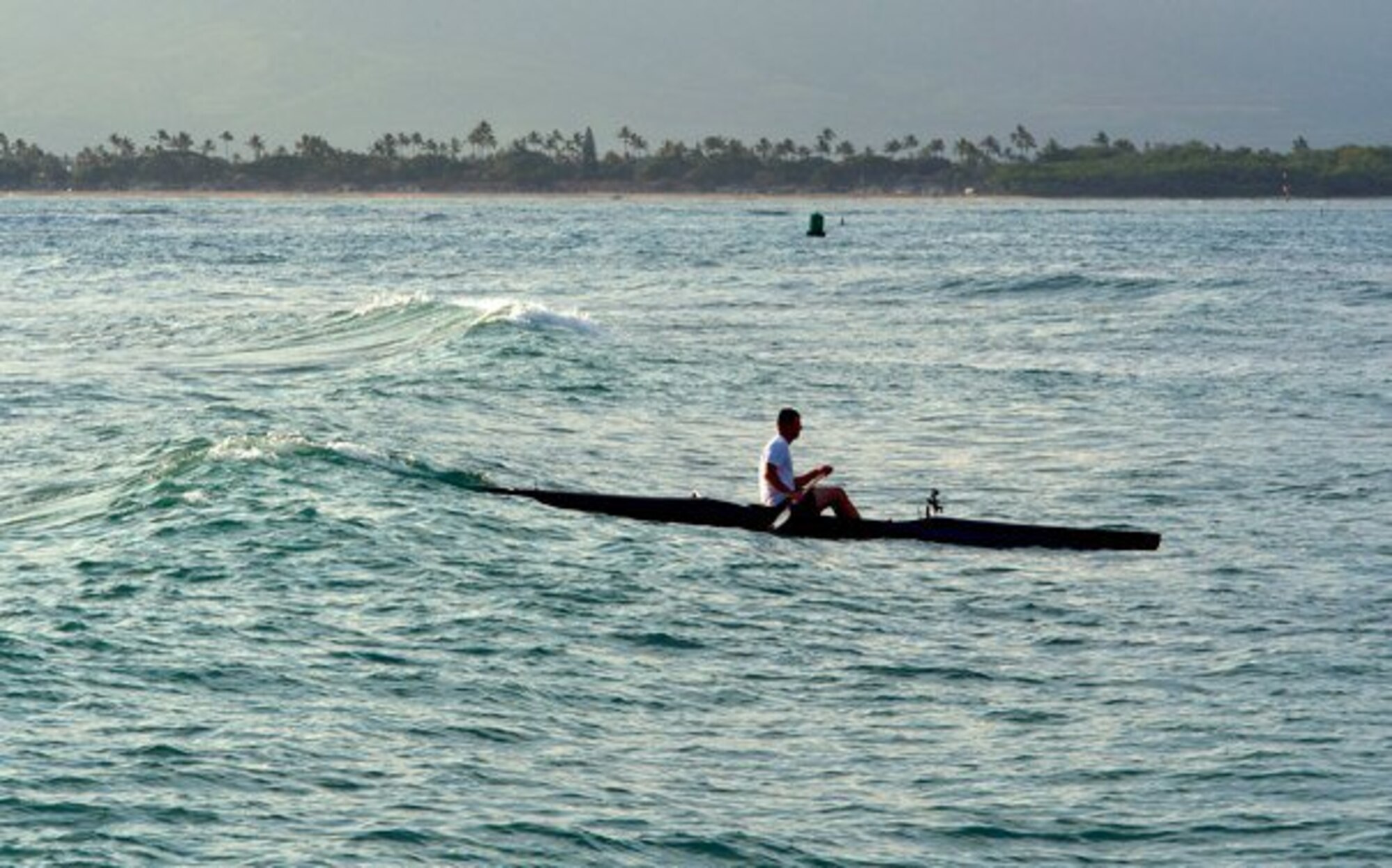 Master Sgt. Jeff Allen, a strategic plans technician with the Pacific  Air Forces public affairs office at Joint Base Pearl Harbor Hickam, paddles a canoe through the water off Hickam Beach Feb. 17. "Paddling" is a popular local pastime in which paddlers brave the Pacific Ocean in outrigger canoes ranging in size from one to six passengers. (U.S. Air Force photo by Staff Sgt. Nathan Allen)