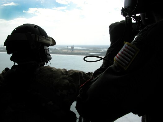 KENNEDY SPACE CENTER, Fla.  - Airmen from the 920th Rescue Wing out of nearby Patrick Air Force base, look on as Space Shuttle Discovery sits majestically on the pad here prior to her last lift off. The Reserve Airmen provide NASA space shuttle support operations. Not only does aircraft maintenance keep Airmen on the go prior to and immediately after space shuttle launches, but as the rescue force charged as guardians of the astronauts, they must be prepared for taking off in their HH-60G Pave Hawk helicopters or HC-130P/N King aircraft to deliver recovery specialists, known as pararescuemen, to save the astronauts life wherever they end up.  (U.S. Air Force photo/Capt. Matthew C. Simpson)