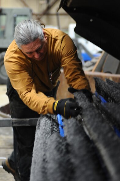 Ron Gillenwater, 28th Civil Engineer Squadron snow removal team member, removes broom core from an air blaster sweeper at Ellsworth Air Force Base, S.D., Feb. 24, 2011. The snow removal team uses a variety of specialized equipment to sweep, blow and scrape snow from different paved areas. (U.S. Air Force photo/Senior Airman Kasey Close)