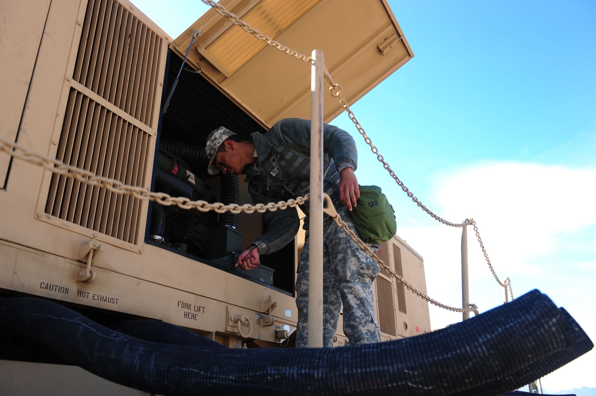 CALIENTE, Nev. -- Spc. Willie Riddick, 1-7 Air Defense Artillery Battalion Patriot Engage Station operator, services engine fluids on an electrical power plant vehicle during Operation Red Flag 11-3 Feb. 24, 2011. The battalion's mission is to provide air defense for friendly forces and allies to allow freedom of maneuver. Red Flag is a realistic combat training exercise that provides heavily-contested and degraded operational environments to prepare crews for major combat operations against a near-peer adversary. (U.S. Air Force photo by 2nd Lt. Tony Richardson) (Released)