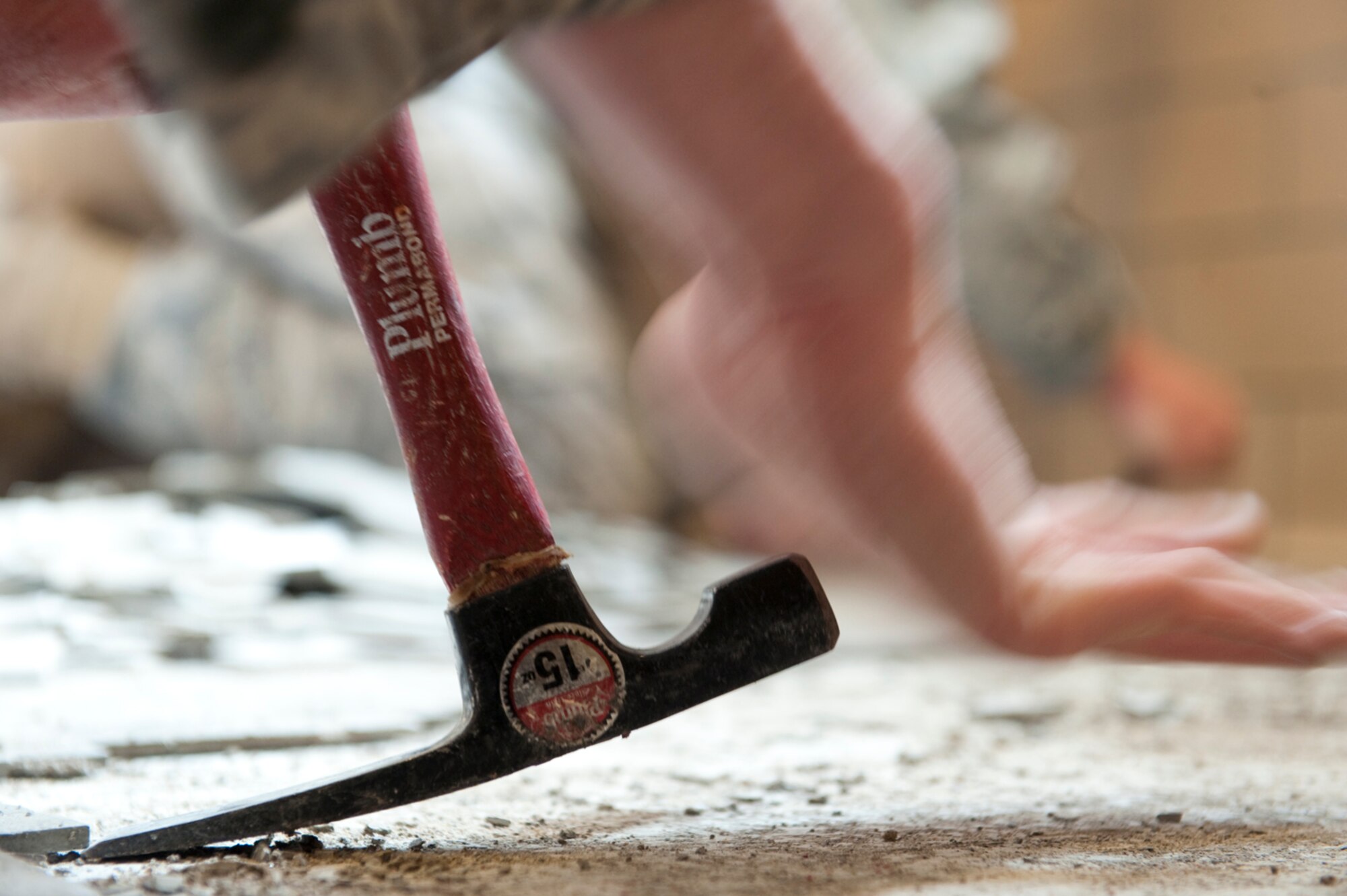 HOLLOMAN AIR FORCE BASE, N.M. -- Airman 1st Class Tyler Huisken, 49th Civil Engineer Squadron, uses a claw hammer to rip out tile at the 746th Test Squadron facility Feb. 16, 2011. This repair is one of many after a record breaking February snow storm. In large part to their efforts, the base's day-to-day operations were able to resume, without delay, when storm the passed.(U.S. Air Force photo by Senior Airman Veronica Stamps/ Released)
