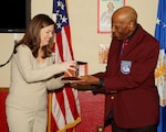 Dr. Granville Coggs, a former Tuskegee Airman, hands Tami Cook the 37th Training Wing Key Spouse of the Year Award during the 323rd Training Squadron commander's call Feb. 14. Mrs. Cook is also the 37th TRW nominee for the Joan Orr Spouse of the Year Award. (U.S. Air Force photo/Antonio Morano)