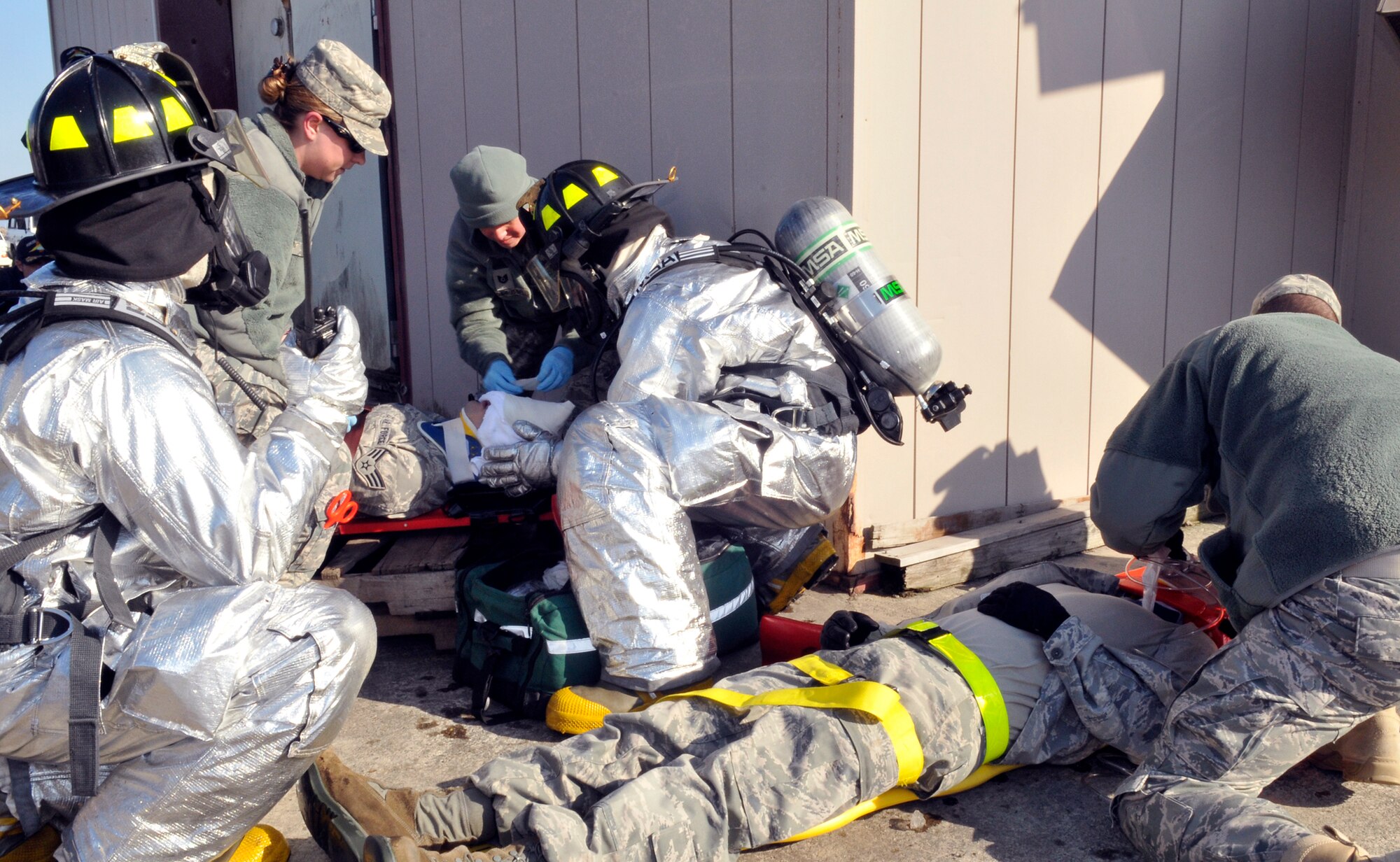 Members of the 35th Medical Group and firemen from the 35th Civil Engineer Squadron work together to stabilize two "injured" Airmen for transportation to a local hospital during an exercise Feb. 23, 2011, in Misawa City, Japan. (U.S. Air Force photo/Tech. Sgt. Phillip Butterfield)