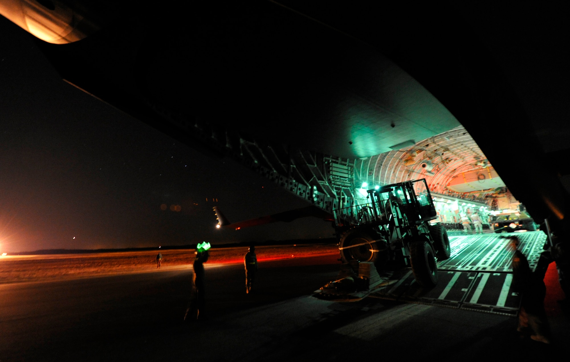 JOINT BASE MCGUIRE-DIX-LAKEHURST, N.J. – Aerial porters from the 621st Contingency Response Wing drive an articulated forklift from a McGuire Air Force Base-assigned C-17 Globemaster II during a nighttime engine-running offload at Lakehurst Naval Air Engineering Station Feb. 23. The Airmen were participating in a field training exercise to hone the wing’s ability to deploy worldwide to austere locations and provide mobility airlift support. (U.S. Air Force photo/Tech. Sgt. Parker Gyokeres/released)