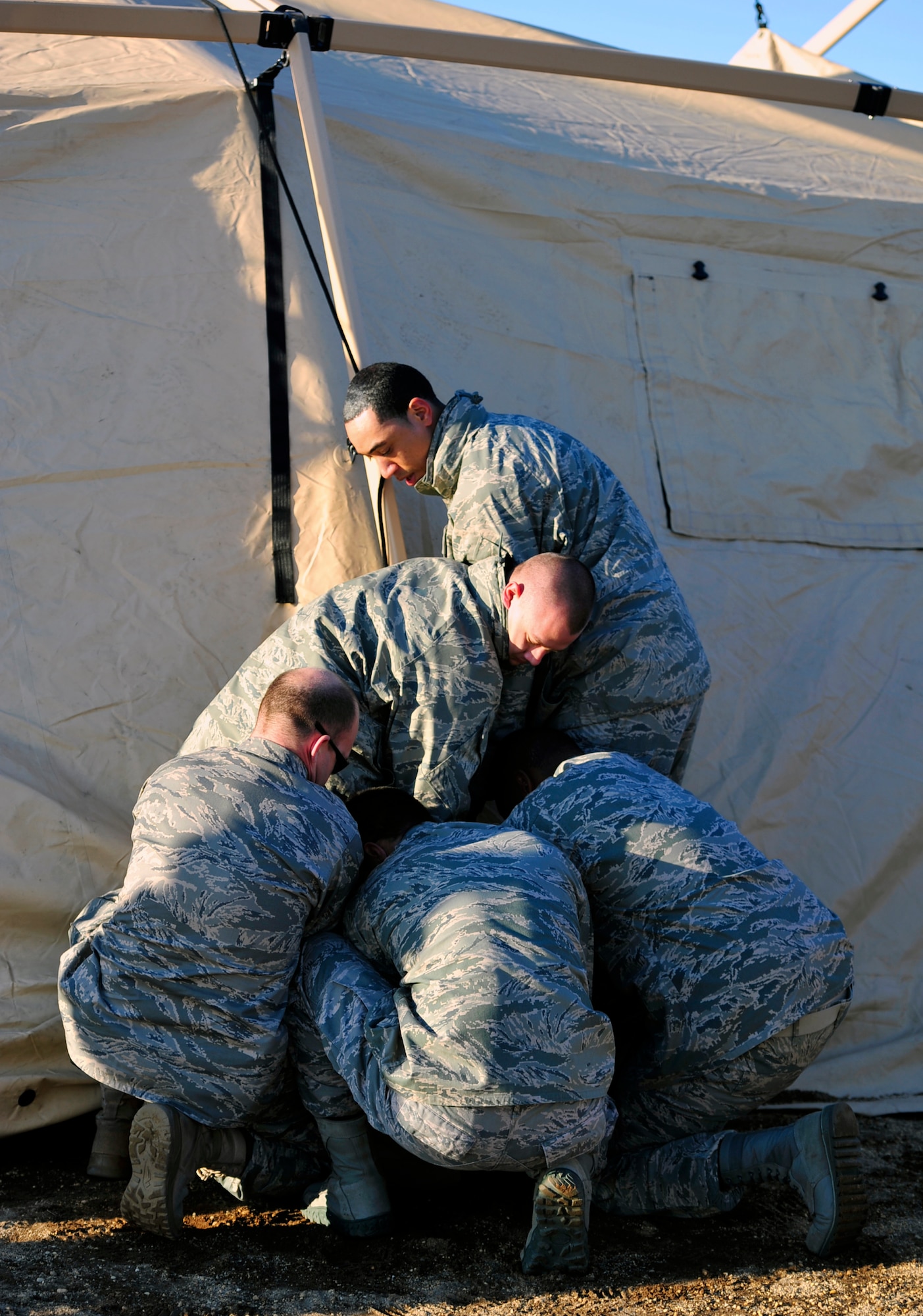 JOINT BASE MCGUIRE-DIX-LAKEHURST, N.J. – Mobility Airmen from the 621st Contingency Response Wing secure a rope to the side of a command and control tent during a field training exercise at the Lakehurst Naval Air Engineering Station Feb. 23.  The tent will house the deployed unit’s logistics, communications and command-and-control elements, and will be used to coordinate safe processing of incoming and departing air cargo from the austere training location. (U.S. Air Force photo/Tech. Sgt. Parker Gyokeres/released)