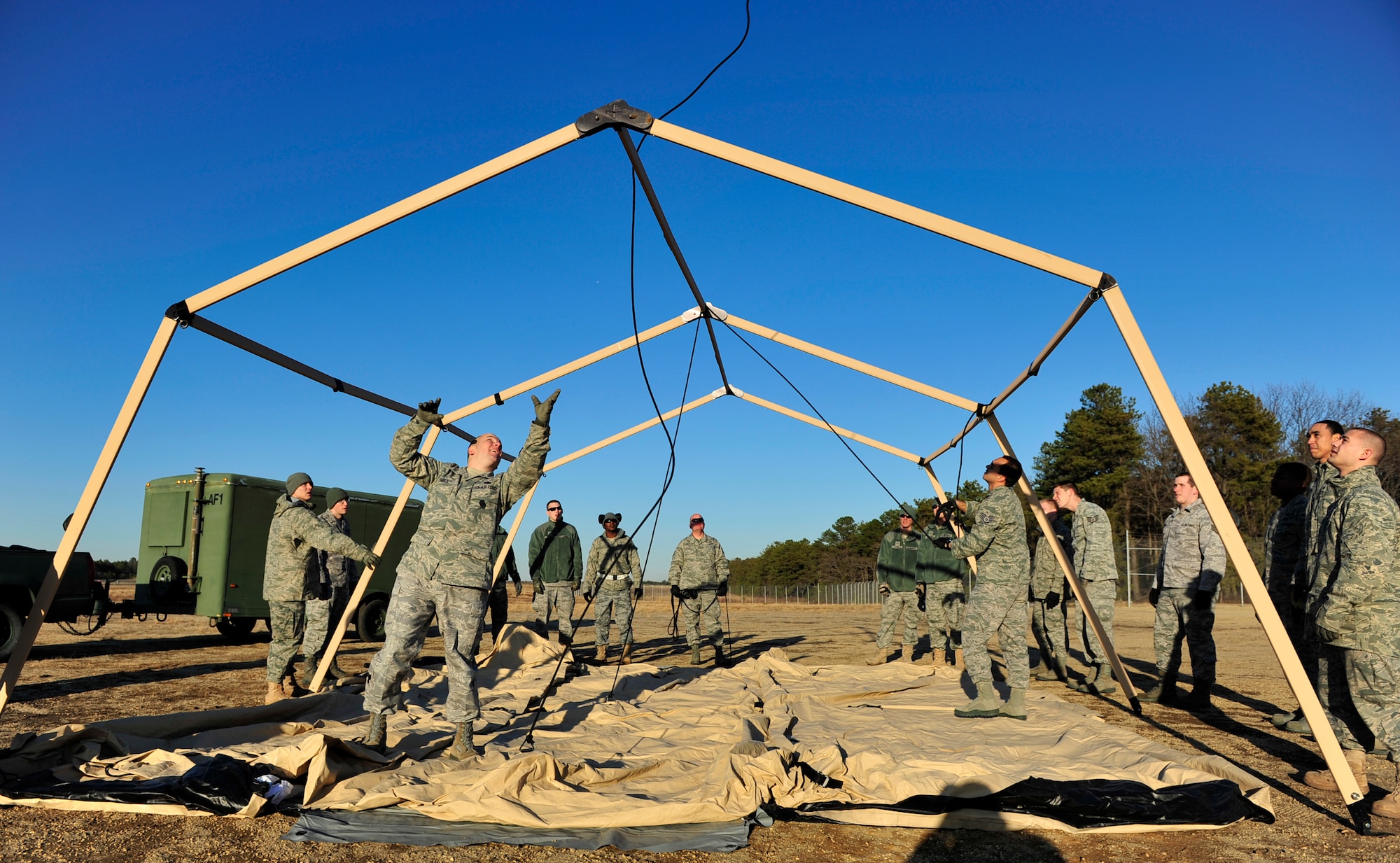 JOINT BASE MCGUIRE-DIX-LAKEHURST, N.J. – Tech. Sgt. Jeff Fairlie, 817th Global Mobility Squadron joint inspection team leader, throws a lift rope used to raise a command-and-control tent during a field training exercise at the Lakehurst Naval Air Engineering Station Feb. 23. Sergeant Fairlie and other members of the 621st Contingency Response Wing were setting up the structure to house communications and logistics specialists that would coordinate the arrival of cargo aircraft with more equipment. (U.S. Air Force photo/Tech. Sgt. Parker Gyokeres/released) 