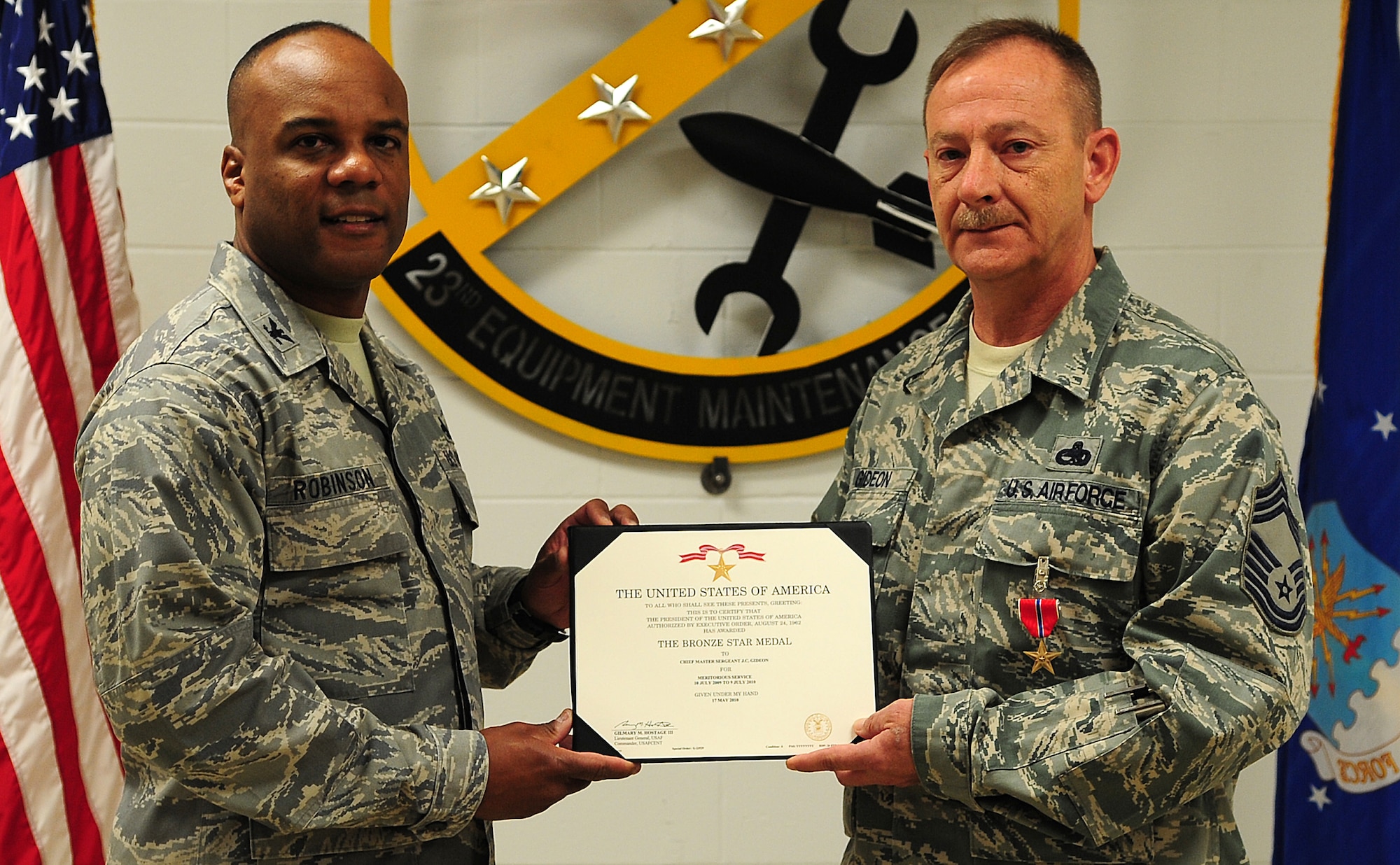 MOODY AIR FORCE BASE, Ga.-- Col. Neal Robinson, 23rd Maintenance Group commander, awards Chief Master Sgt. J.C. Gideon, 23rd Equipment Maintenance Squadron chief enlisted manager, with the Bronze Star Medal certificate Feb. 25. Chief Gideon earned the medal for meritorious service from July 10, 2009 to July 9, 2010. (U.S. Air Force photo/Senior Airman Stephanie Mancha)(RELEASED)