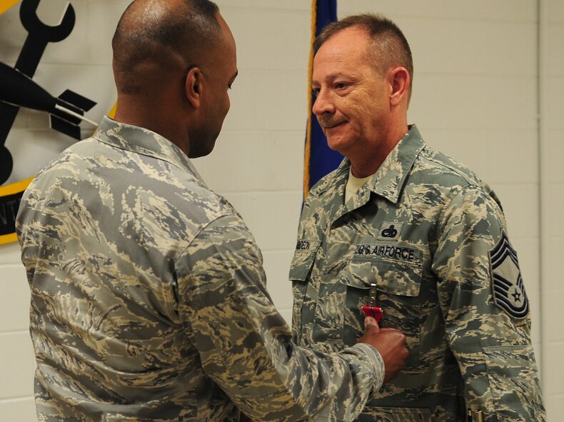 MOODY AIR FORCE BASE, Ga.-- Col. Neal Robinson, 23rd Maintenance Group commander, awards Chief Master Sgt. J.C. Gideon, 23rd Equipment Maintenance Squadron chief enlisted manager, with the Bronze Star Medal Feb. 25. Chief Gideon earned the medal for meritorious service as superintendent of the 379th Expeditionary Maintenance Squadron while supporting ground and air operations against the enemy at Al Udeid Air Base, Qatar. (U.S. Air Force photo/Senior Airman Stephanie Mancha)(RELEASED)
