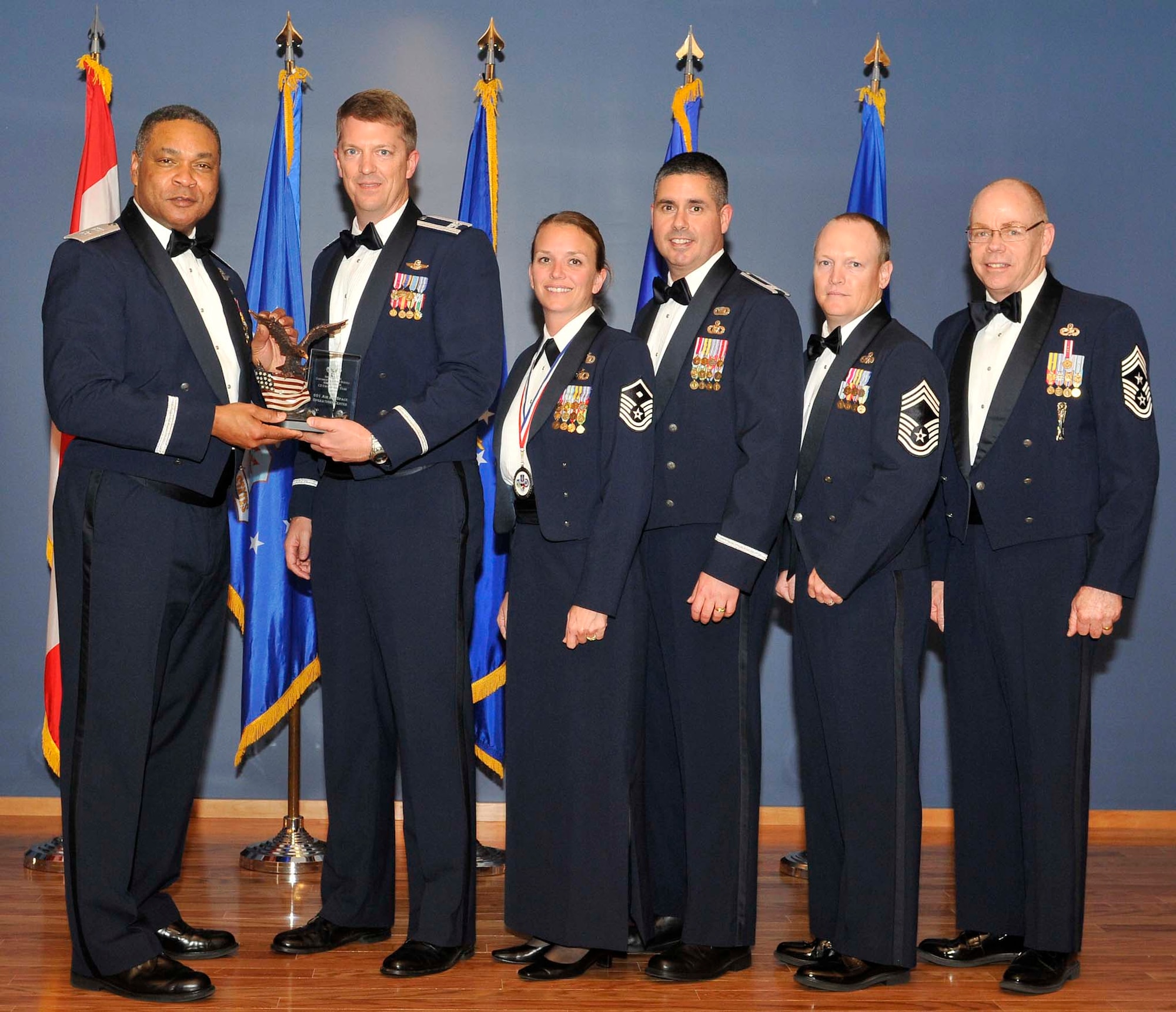 Maj. Gen. Garry C. Dean (left), Continental U.S. NORAD Region-1st Air Force (Air Forces Northern) commander, and Chief Master Sgt. Joseph Thornell (far right), AFNORTH command chief, present a trophy to Col. Randy Spear (second from left) and members of the 601st Air and Space Operations Center, which was selected as the Command and Control Unit of the Year for 1st AF. The 601st AOC was among the many honorees during the organization’s annual awards banquet Feb. 24 at the Horizons Community Center at Tyndall Air Force Base, Fla. (U.S. Air Force photo by Lisa Norman)