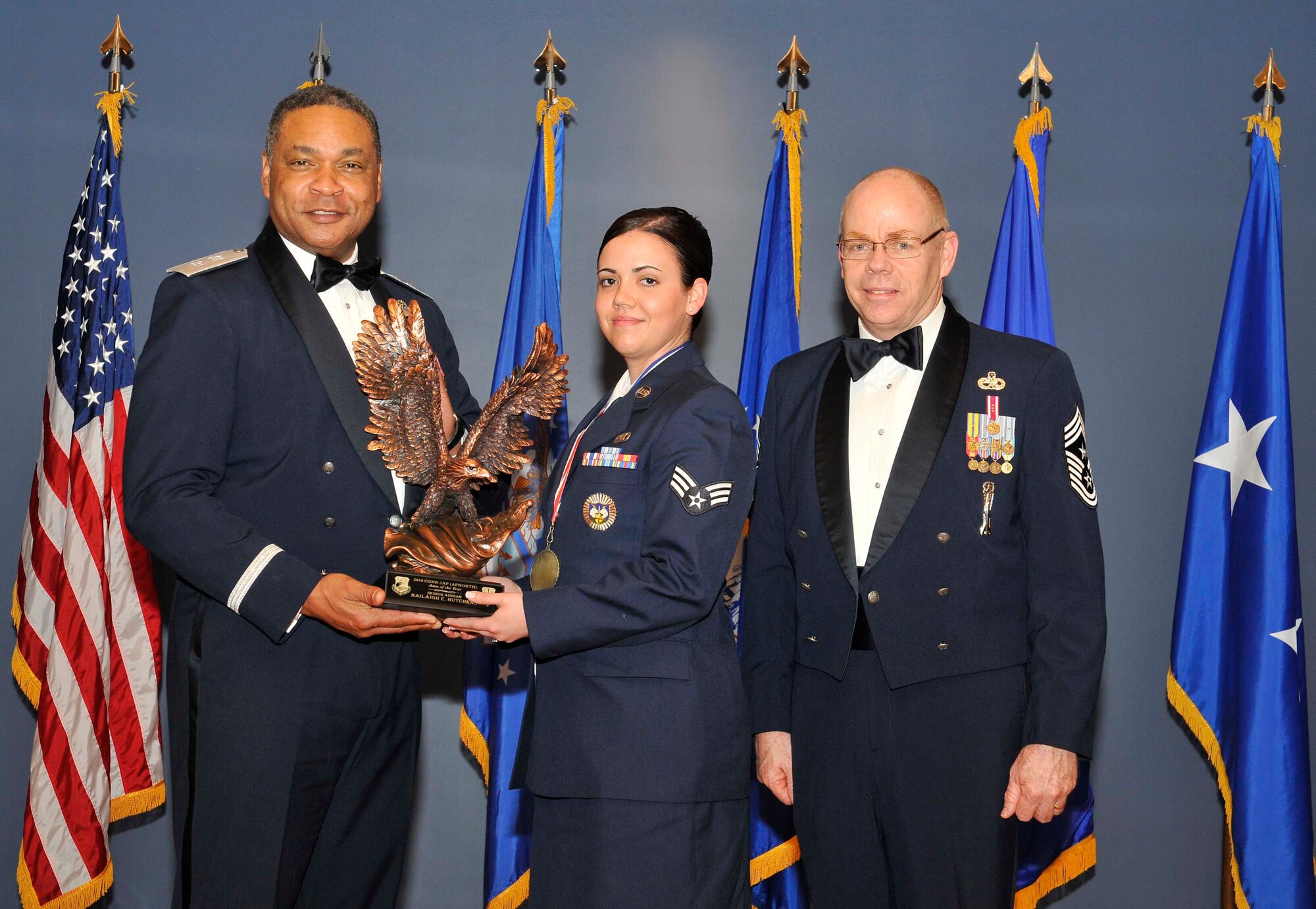 Maj. Gen. Garry C. Dean, Continental U.S. NORAD Region-1st Air Force (Air Forces Northern) commander, and Chief Master Sgt. Joseph Thornell, AFNORTH command chief, present a trophy to Senior Airman Kailaigh Hutchens for earning Airman of the Year honors. Airman Hutchens was one of several Airmen recognized during the organization’s annual awards banquet Feb. 24 at the Horizons Community Center at Tyndall Air Force Base, Fla. (U.S. Air Force photo by Lisa Norman)