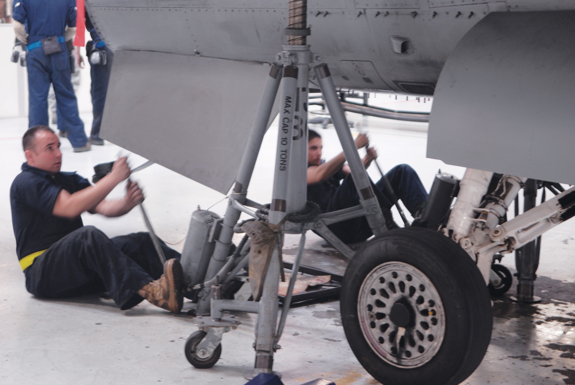 Senior Airman Anothony Griffin, left, and Airman 1st Class Jacob Gonzalez, 56th Equipment Maintenance Squadron phase team members, jack the tail end of the landing gear on the aircraft at phse dock three.  (U.S. Air Force photo/Aiman David Owsianka)