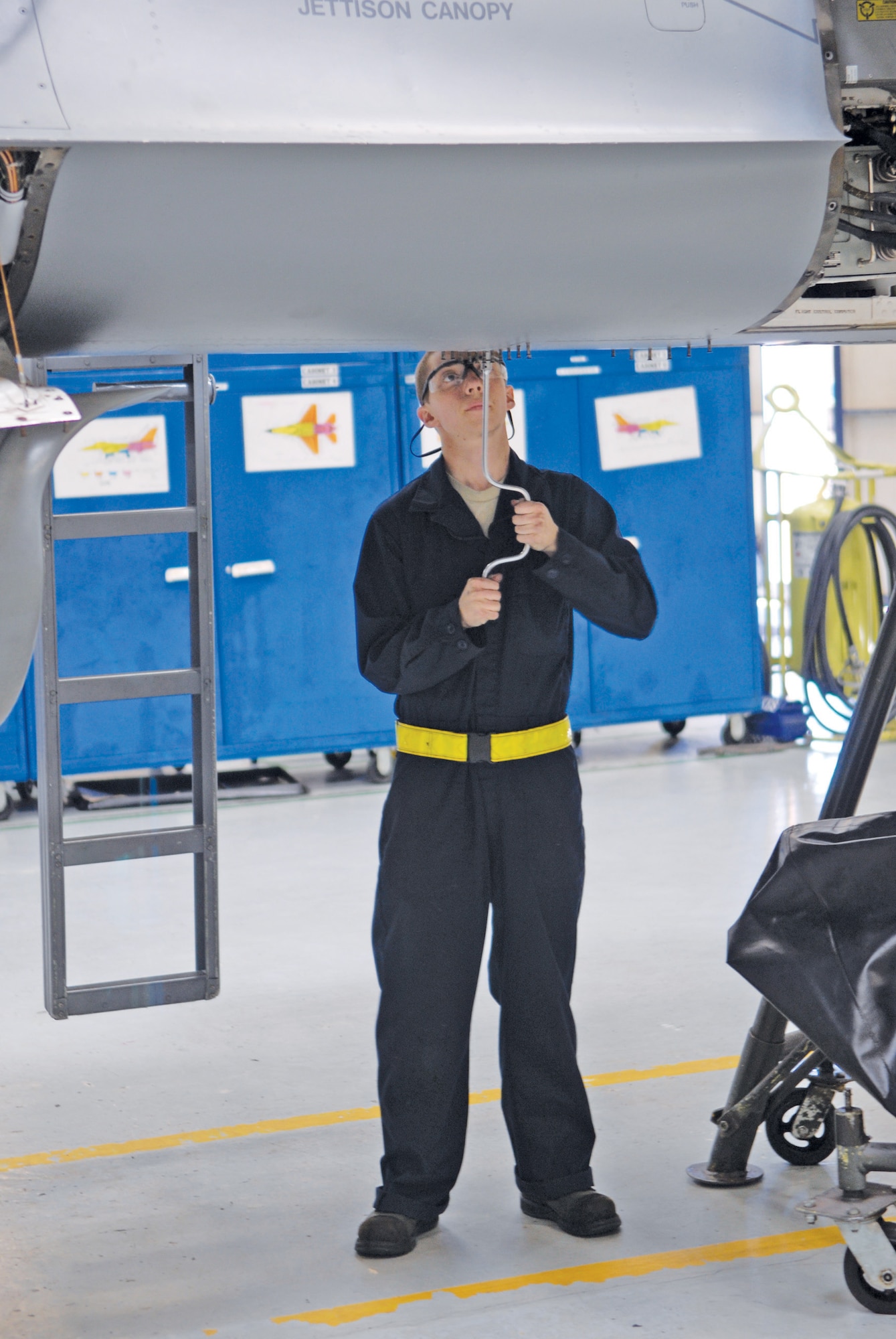 Airman 1st Class Sean Williams, 56th Equipment Maintenance Squadron phase team member, opens a circuit breaker panel when the aircraft is raised at phase dock three.  Raising the jet allows Airmen easier access to fix it.  (U.S. Air Force photo/Aiman David Owsianka)
