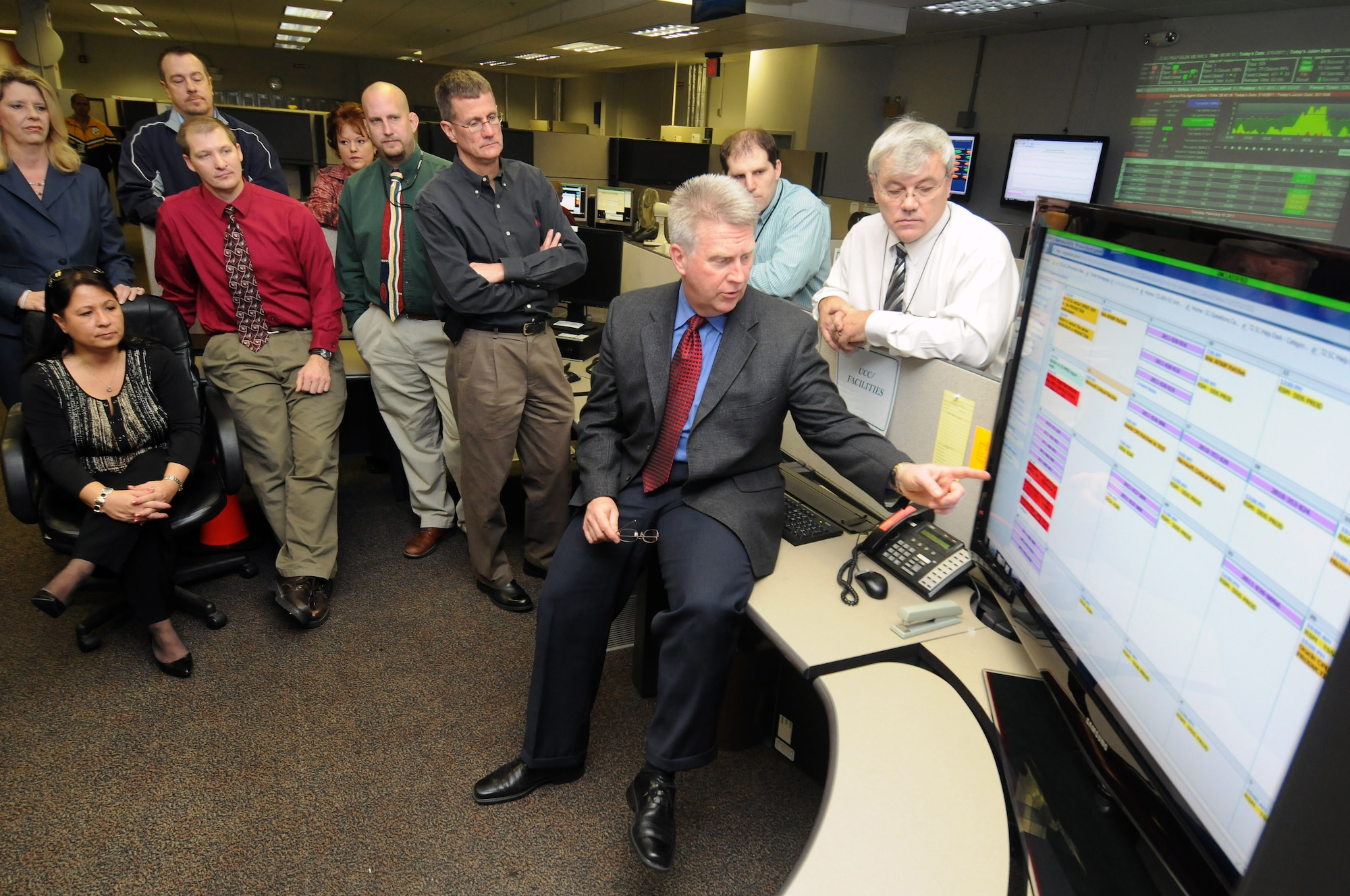 Mike Doolin, director of the 72nd Air Base Wing Communications Directorate, refers to the SC Maintenance Activity Calendar while conducting the daily operations center meeting with SC management personnel. The daily meeting helps SC review and discuss the status of scheduled maintenance activities, and has increased overall efficiency in operations. (Air Force photo by David Faytinger)