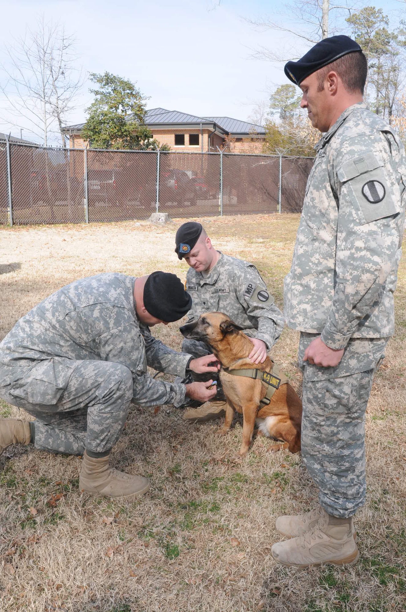 Spc. Matthew Bedortha (center) and Sgt. Mathew Stoner (right) look on as Lt. Col. Oliver Rose, 733d Security Forces Squadron commander, awards the Army Achievement Medal to Chay.(Photo by Lyna Tucker)
