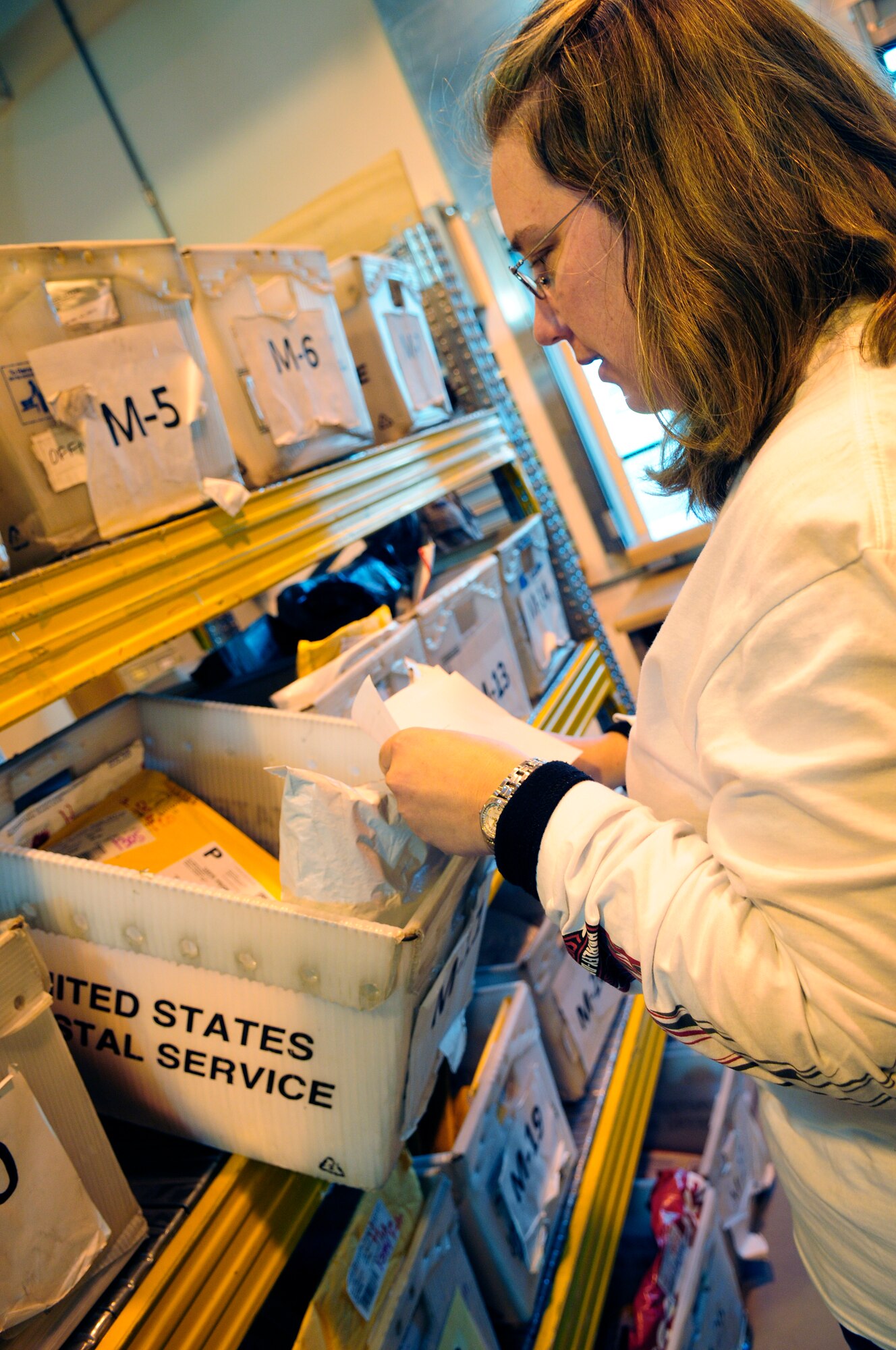 Heidi Spaulding, Aviano Post Office custodian of postal effects, retrieves mail for a customer Feb. 2. Ms. Spaulding recently earned the Outstanding Civilian Assistant award at the U.S. Air Forces in Europe level for her dedicated service at the post office. Among her many accomplishments, Ms. Spaulding assisted in delivering 3.9 million pounds of mail to customers within four hours of receipt, surpassing the Department of Defense average time of delivery by 20 hours. She also conducted education tours of the post office for more than 150 Youth Center children, informing the younger generation about the postal system. (U.S. Air Force photo by Airman 1st Class Katherine Windish)