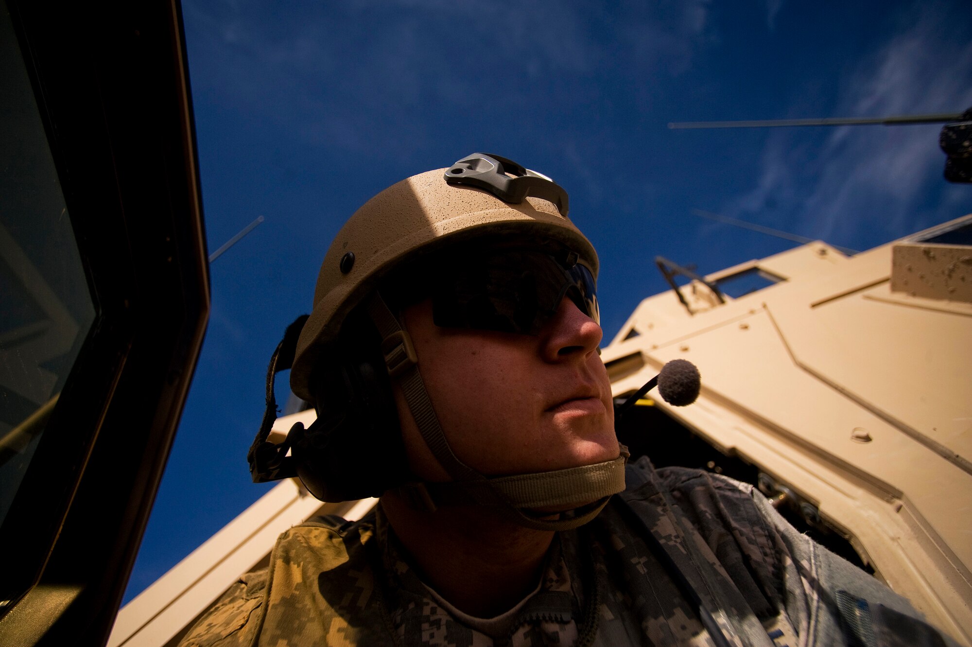 Airman 1st Class Brandon Shamhart a Tactical Air Control Party (TACP) Radio Operator Maintenance And Driver (ROMAD), 807th Expeditionary Air Support Operations Squadron, Forward Operating Base Lagman deployed from the 2nd Air Support Operations Squadron, Vilseck, Germany listens to the chatter of a C-130 Hercules aircrew via his radio in a Mine Resistant Ambush Protected vehicle at a dirt landing zone in the Zabul Province of Afghanistan. Airman Shamhart  was there to help make sure the dirt landing zone was safe for a cargo carrying C-130 Hercules to land and provide the aircrew with any pertinent information via radio communications. The aircrew was delivering needed cargo for one of the nearby military outposts. (U.S. Air Force Photo/ Master Sgt. Adrian Cadiz)(Released)