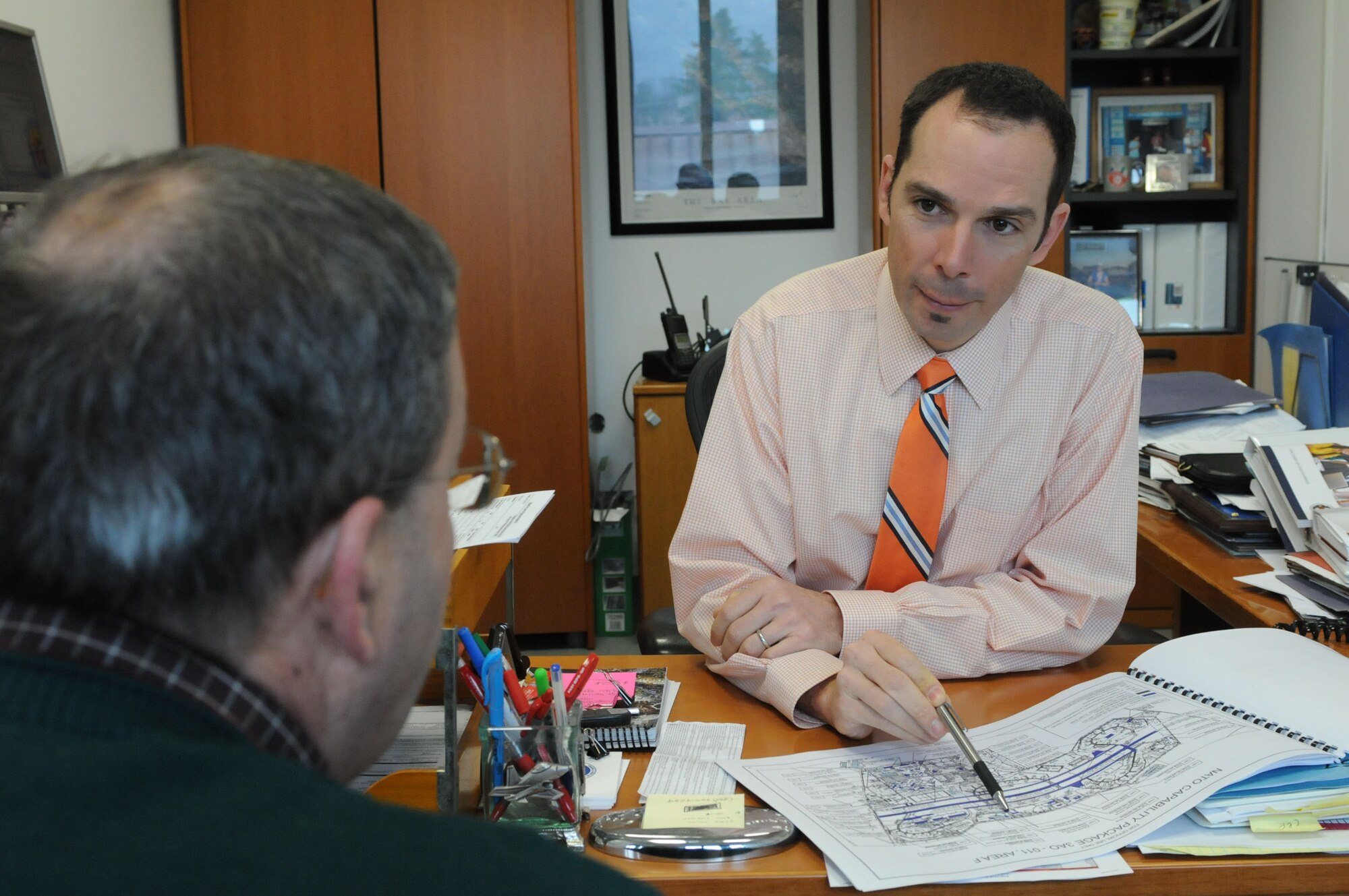 Adam Leigland, 31st Civil Engineer Squadron deputy base civil engineer, discusses base engineering plans with a 31st CES coworker Feb. 23. Mr. Leigland recently received the 2010 U.S. Air Forces in Europe Civil Engineer National Society of Professional Engineers Federal Engineer of the Year award. (U.S. Air Force photo/Staff Sgt. Julius Delos Reyes)