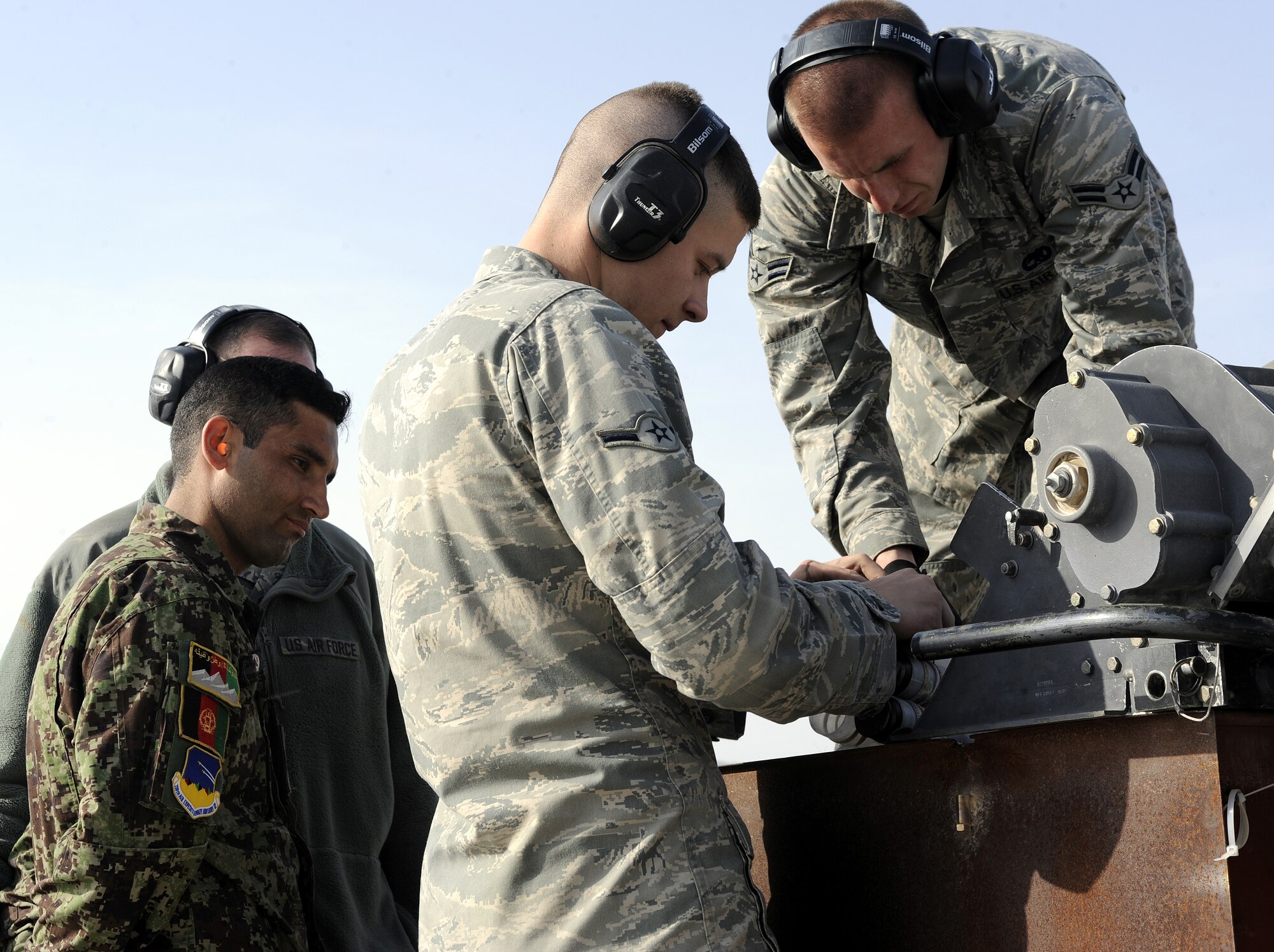 Airman 1st Class Kevin Jones and Airman Quinten Gregersen link 30 mm rounds together during an ammo upload on an A-10C Thunderbolt II during a demonstration for the Afghan air force, Feb. 22, 2011, at Kandahar Airfield, Afghanistan. The munitions demonstration was organized to a safe, efficient weapons load. The Airmen are load crew team members assigned to the 451st Expeditionary Aircraft Maintenance Squadron. (U.S. Air Force photo/Senior Airman Willard E. Grande II/Released)