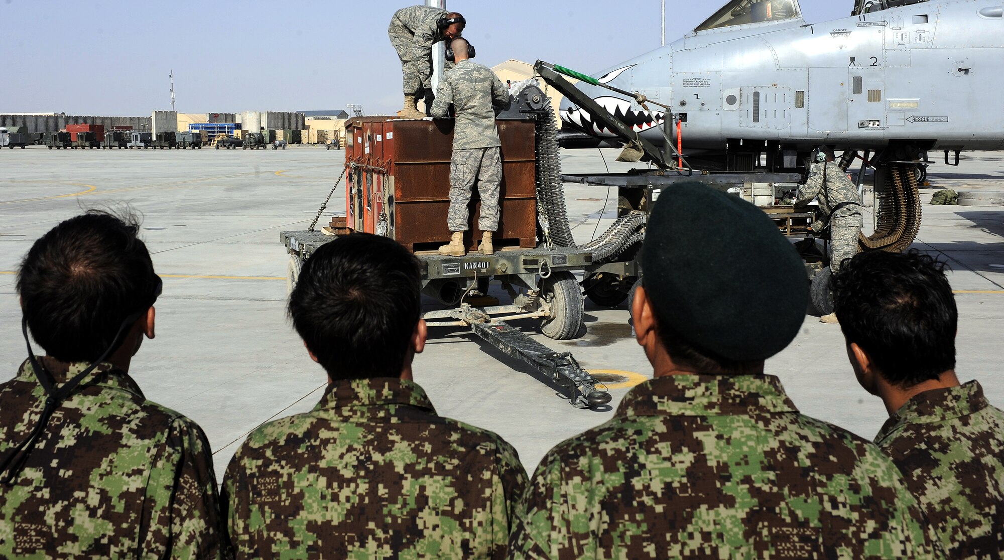Staff Sgt. Harrison Ragin, Airman 1st Class Kevin Jones and Airman Quinten Gregersen perform a 30 mm ammunition upload on an A-10C Thunderbolt II during a demonstration for the Afghan air force, Feb. 22, 2011, at Kandahar Airfield, Afghanistan. The munitions demonstration was organized to show the efficiency and safety that has helped make the U.S. Air Force successful. The Airmen are a load crew team assigned to the 451st Expeditionary Aircraft Maintenance Squadron. (U.S. Air Force photo/Senior Airman Willard E. Grande II/Released)