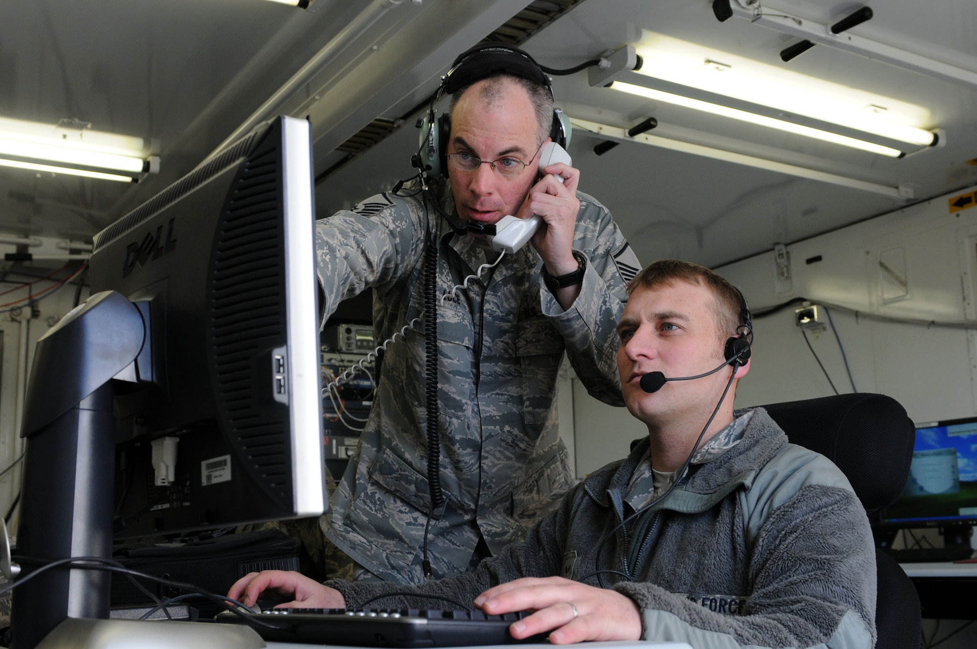 Master Sgt. Fred Luce (left), 603rd Air Control Squadron weapons director, helps Airman 1st Class Luke Roy, 603rd ACS surveillance technician, with 603rd ACS functions. Sergeant Luce recently received the 2010 U.S. Air Forces in Europe Theater Air Control System Outstanding Command and Control Battle Management Operator Senior NCO of the Year award. (U.S. Air Force photo/Staff Sgt. Julius Delos Reyes)
