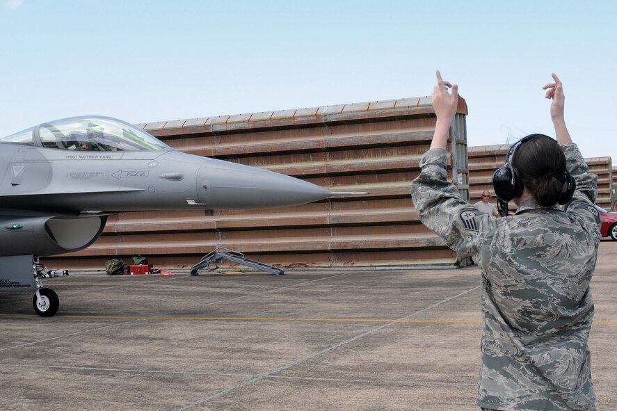 Staff Sgt. Rachel Albee, from the 132nd Fighter Wing (132FW) Security Forces squadron, marshals an F-16 C+ aircraft on the flight line of the Royal Australian Air Force (RAAF) Base, Williamtown, Australia on February 24, 2011.  Sgt. Albee is participating in the technician swap that the 132FW Maintenance Group is conducting for the 132FW and RAAF members during joint flying mission, "Sentry Down Under".  (US Air Force photo/Staff Sgt. Linda E. Kephart)(Released)