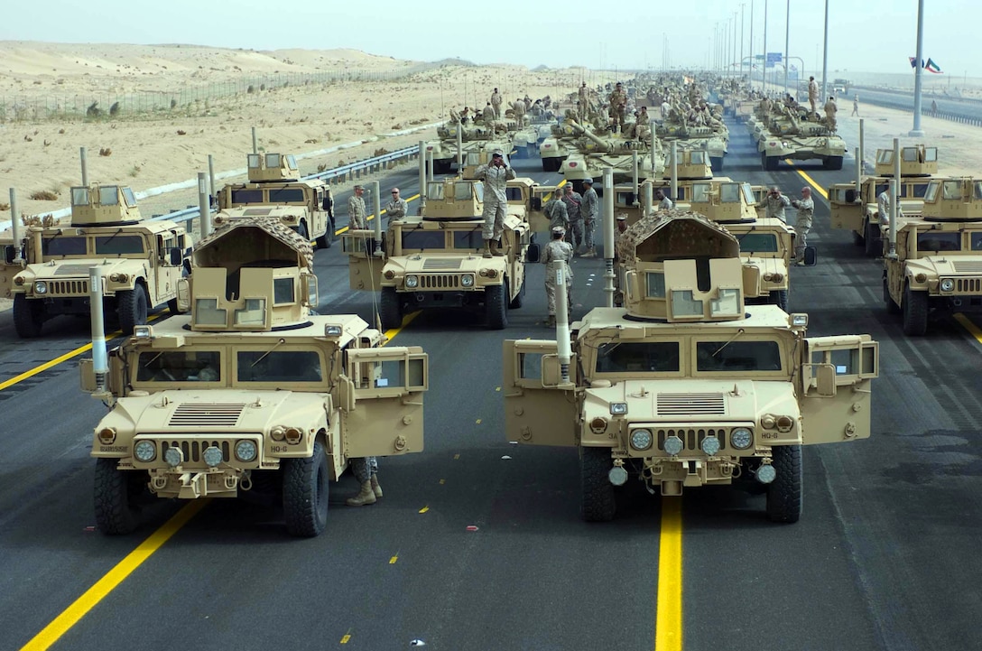 A formation of armored vehicles, manned by U.S. soldiers and Marines, stand ready to lead a convoy of coalition forces through the parade grounds established for the 50/20 celebration in Kuwait City, Kuwait, Feb. 21, 2011. The celebration commemorates the 20th anniversary of the U.S.-led liberation of Kuwait during the first Gulf War and the 50th anniversary of Kuwait’s independence from Great Britain. It also honors the veterans of Operations Desert Shield and Desert Storm and recognizes the long standing and successful partnership that is indicative of U.S. friendships in the region. U.S. Army photo by Sgt. M. Benjamin Gable