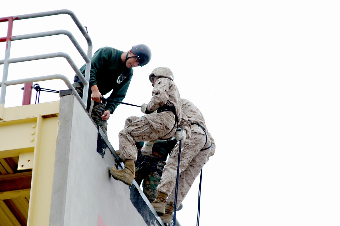 Instructional Training Company drill instructors give the recruits final instructions before they send them down the rappel tower. The drill instructors say it is these final instructions that help the recruits stay focused on the task and not the 100 feet between them and the ground.