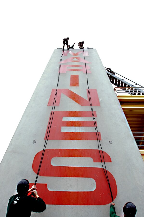 Recruits of Company H descend the rappel tower assisted by ITC drill instructors Feb. 25. The rappel tower is the final confidence course obstacle the recruits must complete during boot camp.