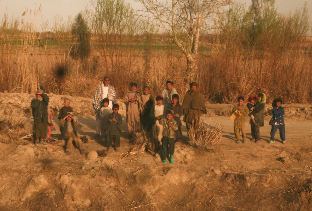 Afghan children wave at a passing convoy from General Support Security Platoon, Headquarters and Service Company, Combat Logistics Battalion 3, 1st Marine Logistics Group (Forward) in Trek Nawa, Afghanistan, Feb. 25, 2011. A Marine presence is fairly new to the area but was met with positive views from locals.