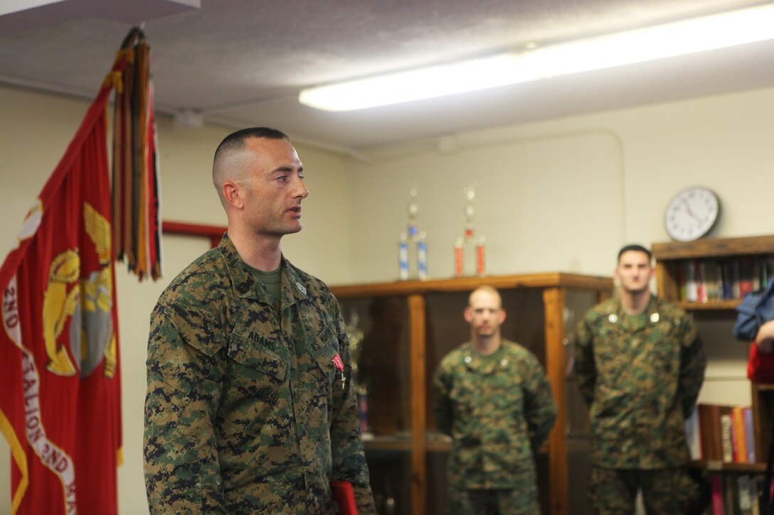 First Sgt. Chris J. Adams, left, Fox Company 1st Sgt with 2nd Battalion, 2nd Marine Regiment, 22nd Marine Expeditionary Unit, speaks to a formation of Marines about dedication after being awarded a Bronze Star Medal with Combat Distinguishing Device aboard Camp Lejeune, N.C., Feb. 25, 2011.  Adams received the high honors for actions performed in Afghanistan in 2010.  The Marines and sailors of the 22nd MEU are in the early stages of their pre-deployment training program, which is a series of progressively complex exercises designed to train and test the MEU's ability to operate as a cohesive and effective Marine Air Ground Task Force.