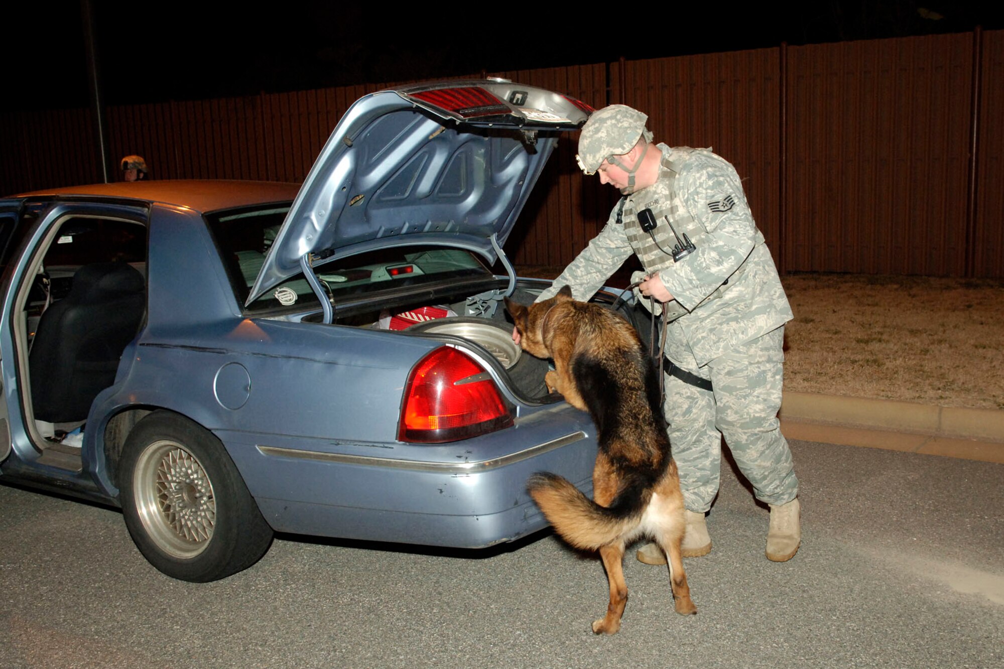 Staff Sgt. Christopher Rocchio and Military Working Dog Argo, 633d Security Forces Squadron MWD section, inspect random vehicles during an Operational Readiness Exercise at Langley Air Force Base, Va., Feb. 26, 2011. SFS, along with MWD, increased random inspections of incoming personnel onto the base during the exercise for evaluation purposes. (U.S. Air Force photo by Airman 1st Class Racheal Watson/Released)