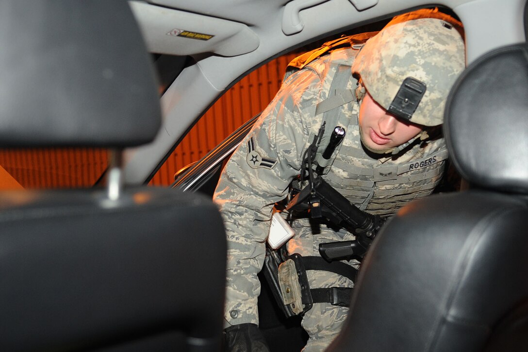 Airman 1st Class Johnathan Rogers, 633d Security Forces Squadron installation entry controller, inspects a vehicle during an Operation Readiness Exercise at Langley Air Force Base, Va., Feb. 26, 2011. Wing exercise evaluation team members spent two days assessing the ability of the 633d Air Base Wing, 1st Fighter Wing and 192d Fighter Wing to deploy cargo, aircraft and Airmen within a limited time frame. (U.S. Air Force photo by Staff Sgt. Ashley Hawkins/Released)