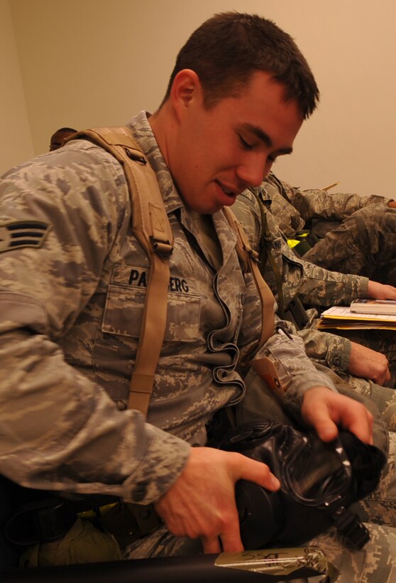 Senior Airman Ryan Palmberg, 27th Aircraft Maintenance Unit F-22 Raptor crew chief, inspects his gas mask while processing through a personnel deployment function line at Langley Air Force Base, Va., Feb. 26, 2011. The PDF line was part of a two-day Operational Readiness Exercise in which the 1st Fighter Wing, 633d Air Base Wing and 192d Fighter Wing worked together to test their ability to deploy Airmen on short notice. (U.S. Air Force photo by Staff Sgt. Logan Tuttle/Released)