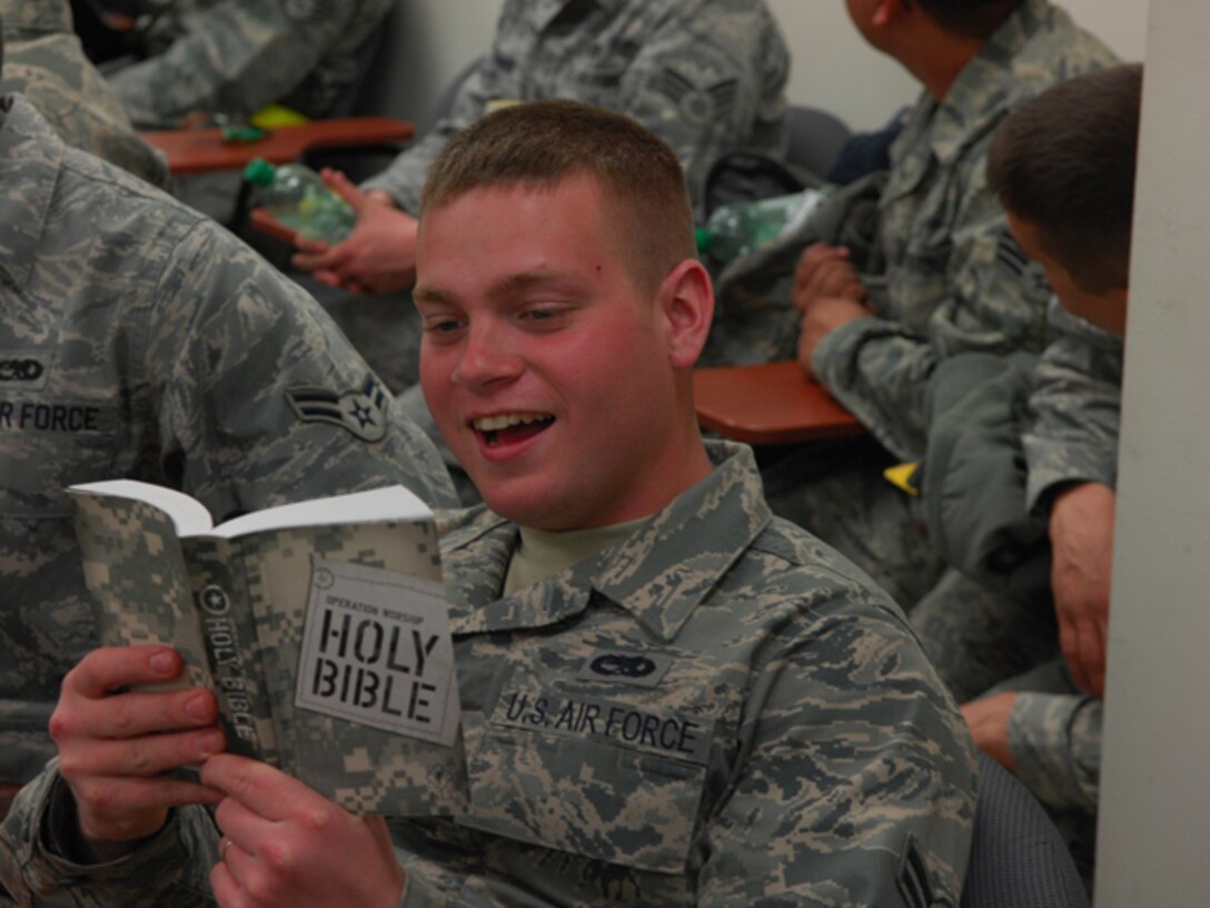 Airman 1st Class Casey Havaich, 27th Aircraft Maintience Unit weapons loader, reads his Bible while processing through a personnel deployment function line at Langley Air Force Base, Va., Feb. 26, 2011. The PDF line was part of a two-day Operational Readiness Exercise in which the 633d Air Base Wing, 1st Fighter Wing and 192d Fighter Wing worked together to test their ability to deploy Airmen, aircraft and cargo on short notice. (U.S. Air Force photo by Airman 1st Class Camilla Elizeu/Released)  