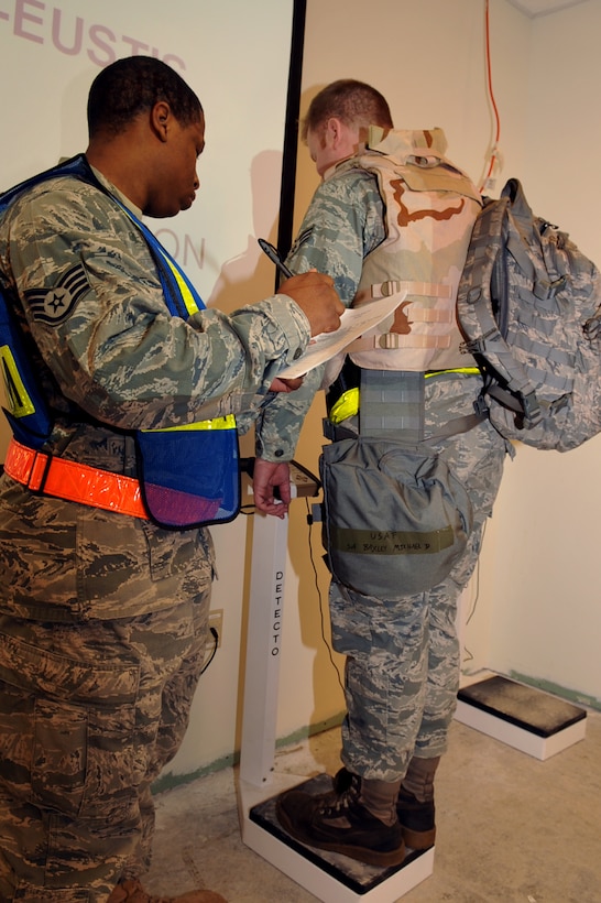 Staff Sgt. Akino Malcum, 633d Force Support Squadron passenger travel craftsman, weighs Senior Airman Michael Baxley, 27th Aircraft Maintenance Unit crew chief, while processing through a personnel deployment function line  at Langley Air Force Base, Va., Feb. 26, 2011. The PDF line was part of a two-day operational readiness exercise in which the 633d Air Base Wing, 1st Fighter Wing and 192d Fighter Wing worked together to test their ability to deploy Airmen, aircraft and cargo on short notice. (U.S. Air Force photo by Staff Sgt. Logan Tuttle/Released)