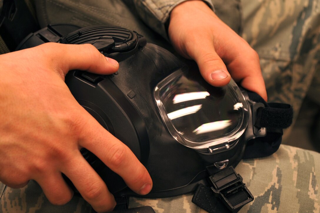 Senior Airman Ryan Palmberg, 27th Aircraft Maintenance Unit F-22 Raptor crew chief, inspects his gas mask while processing through a personnel deployment function line at Langley Air Force Base, Va., Feb. 26, 2011. The PDF line was part of a two-day Operational Readiness Exercise in which the 633d Air Base Wing, 1st Fighter Wing and 192d Fighter Wing worked together to test their ability to deploy Airmen, aircraft and cargo on short notice. (U.S. Air Force photo by Staff Sgt. Logan Tuttle/Released)