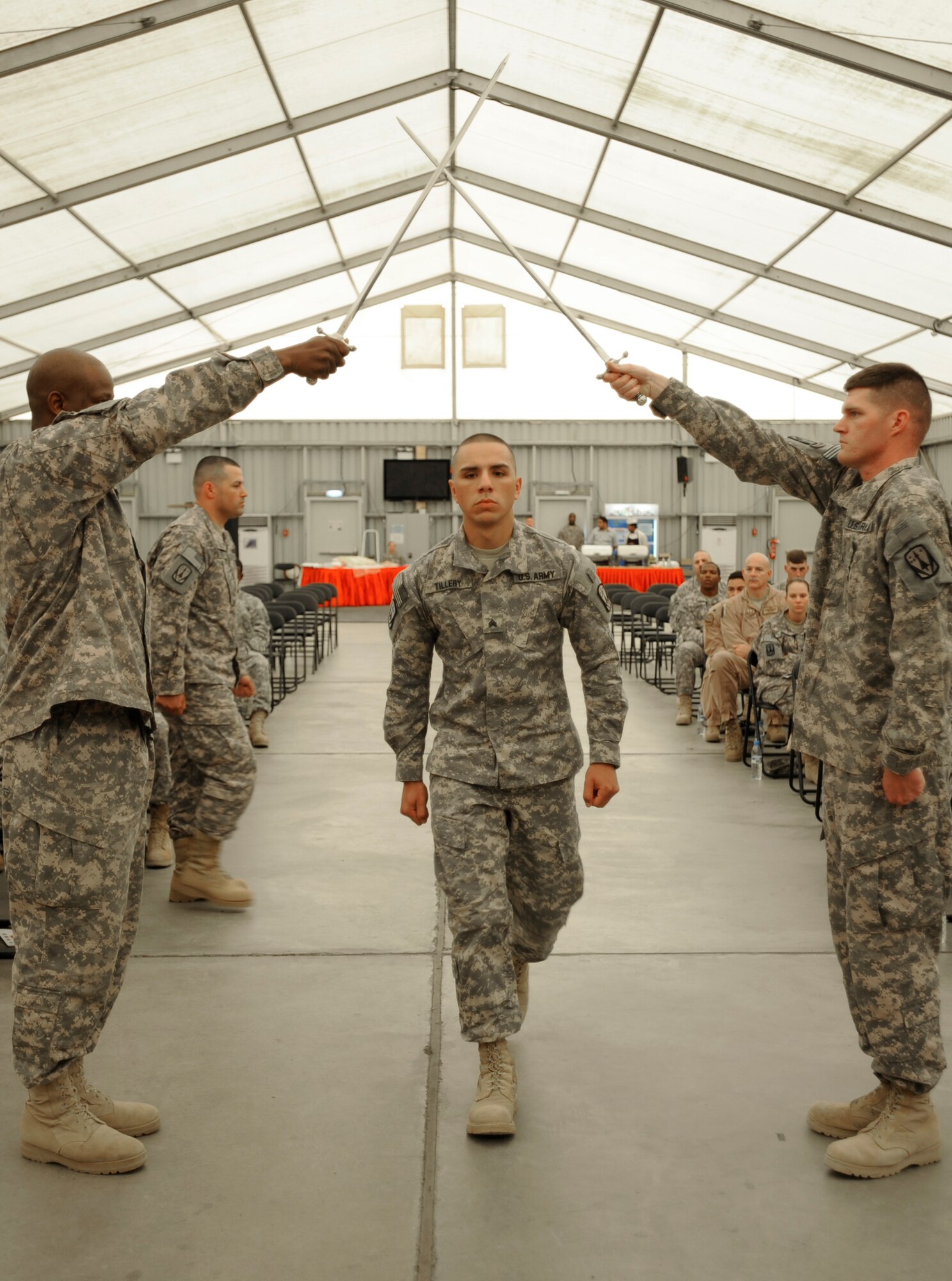 CPL Daniel Tillery, 3rd Battalion-2nd Air Defense Artillery, passes through the gate to becoming the 3rd Battalion's newest Non-Commissioned Officer Feb. 25, 2011, in Southwest Asia. CPL Tillery was one of the nine soldiers to be inducted in this ceremony. (U.S. Air Force photo by Senior Airman Maynelinne De La Cruz) 