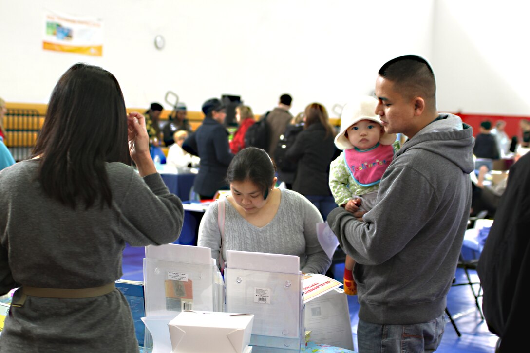 Terra Pack, home visitor with the New Parent Support Program, speaks with Petty Officer 3rd Class Peejay Panganiban and his wife Petty Officer 2nd Class Lizette Panganiban, both hospital corpsman stationed with Balboa and Camp Pendleton respectively, about the opportunities available to them and their new daughter at the 4th annual Exceptional Family Member Program Activity and Resource Expo Feb. 26 at the Marine Corps Recruit Depot San Diego Field House. The EFMP assists families with special needs to find the resources they need to ensure a safe and happy home. The expo hosted 48 booths that offered assistance to families of all sorts and were all TRICARE authorized. Lunch was also provided for the more than 150 guests in attendance.