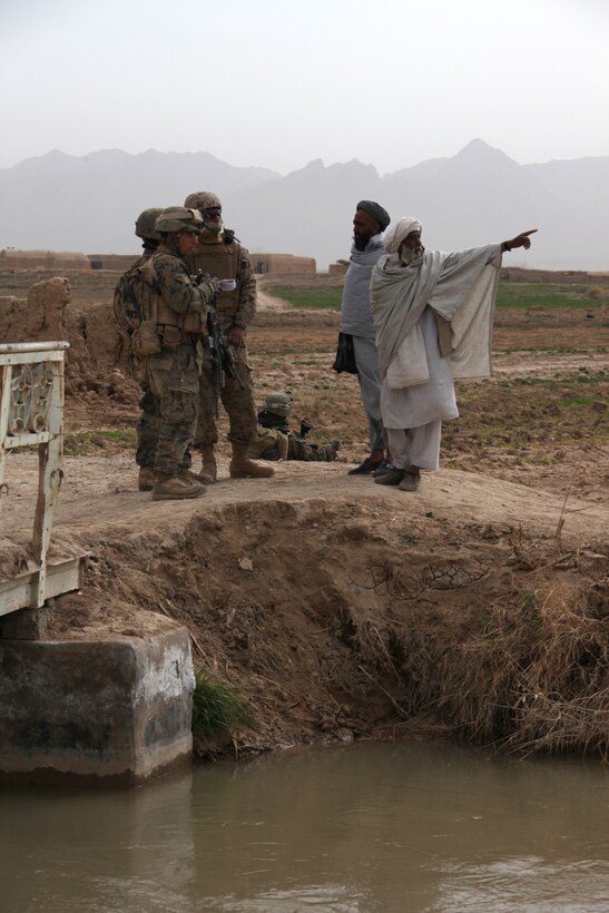 U.S. Marine Corps Lance Cpl. Cooper Guadiosi, Cpl. William Moore and interpreter Ajmal Kakal, all with 2nd Platoon, Company I, Battalion Landing Team 3/8, 26th Marine Expeditionary Unit, Regimental Combat Team 8, speak to a local Afghan at a vehicle check point at a bridge crossing the Nahr-e Saraj canal in Helmand province, Afghanistan, Feb. 27, 2011. Elements of 26th Marine Expeditionary Unit deployed to Afghanistan to provide regional security in Helmand province in support of the International Security Assistance Force.